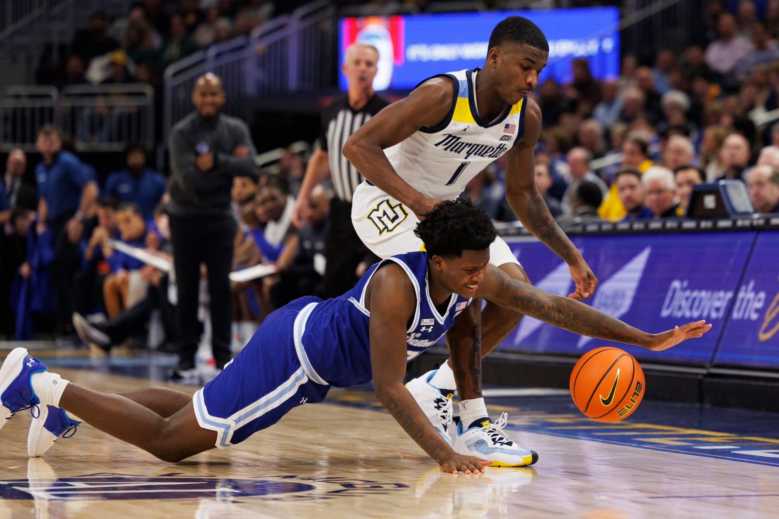 Dec 27, 2022; Milwaukee, Wisconsin, USA;  Seton Hall Pirates guard Jaquan Sanders (20) and Marquette Golden Eagles guard Kam Jones (1) chase the loose ball during the first half at Fiserv Forum. Mandatory Credit: Jeff Hanisch-Imagn Images