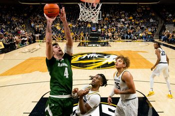 Nov 25, 2023; Columbia, Missouri, USA; Loyola (Md) Greyhounds forward Alonso Faure (4) shoots against Missouri Tigers guard Sean East II (55) and forward Noah Carter (35) during the second half at Mizzou Arena. Mandatory Credit: Jay Biggerstaff-Imagn Images