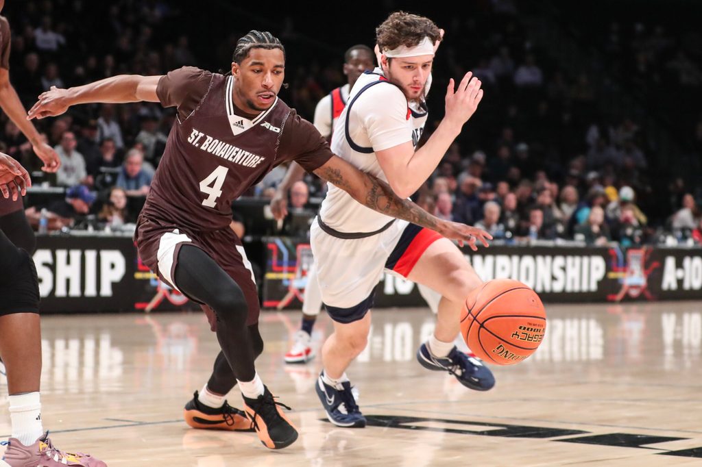 Mar 16, 2024; Brooklyn, NY, USA; St. Bonaventure Bonnies guard Moses Flowers (4) and Duquesne Dukes guard Jake DiMichele (44) fight for a loose ball in the first half at Barclays Center. Mandatory Credit: Wendell Cruz-Imagn Images