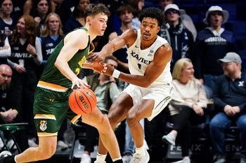 Xavier Musketeers guard Marcus Foster (1) defends against Siena Saints forward Brendan Coyle (21) in the second half of a college basketball game between the Xavier Musketeers and Siena Saints, Wednesday, Nov. 20, 2024, at Cintas Center in Cincinnati. Musketeers won 80-55.