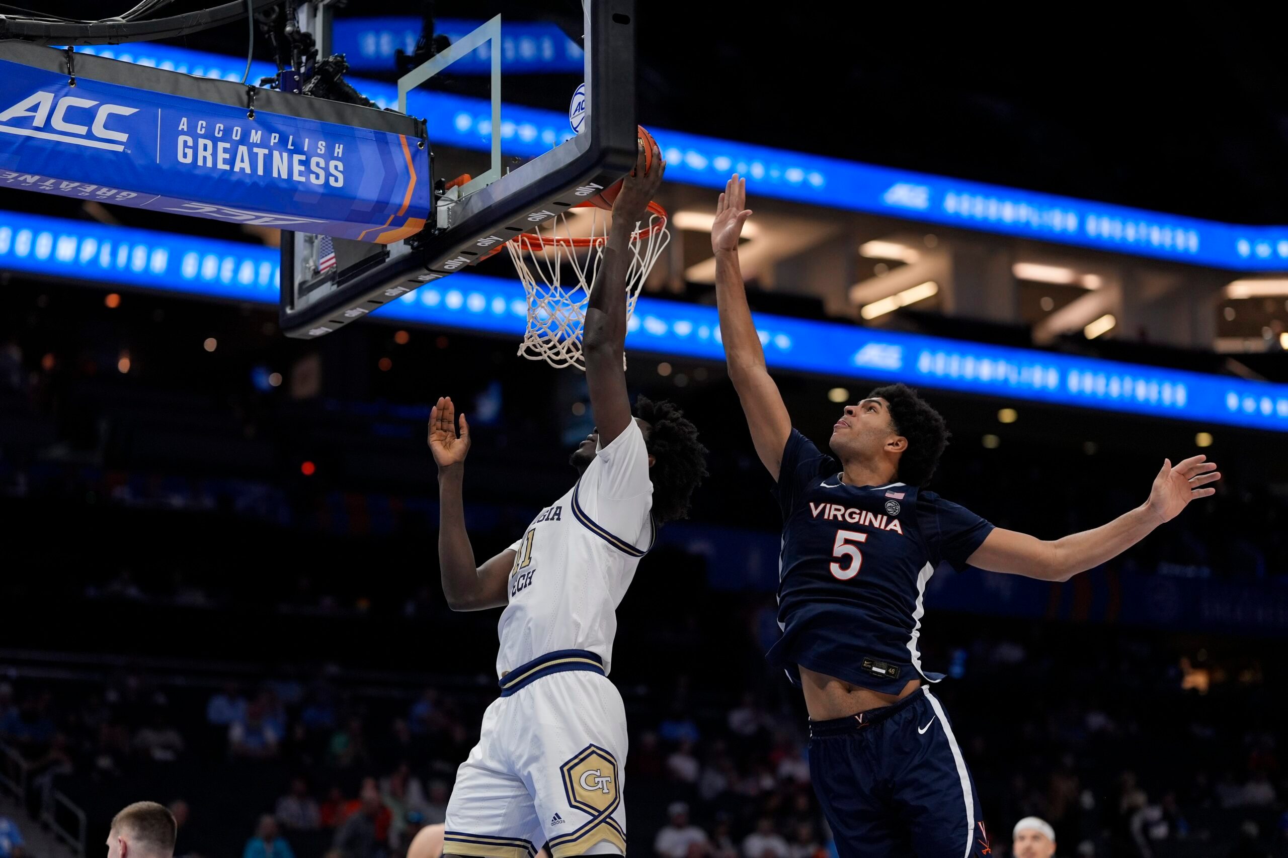 Mar 12, 2025; Charlotte, NC, USA; Georgia Tech Yellow Jackets forward Baye Ndongo (11) goes to the basket defended by Virginia Cavaliers forward Jacob Cofie (5) during the second half at Spectrum Center. Mandatory Credit: Jim Dedmon-Imagn Images