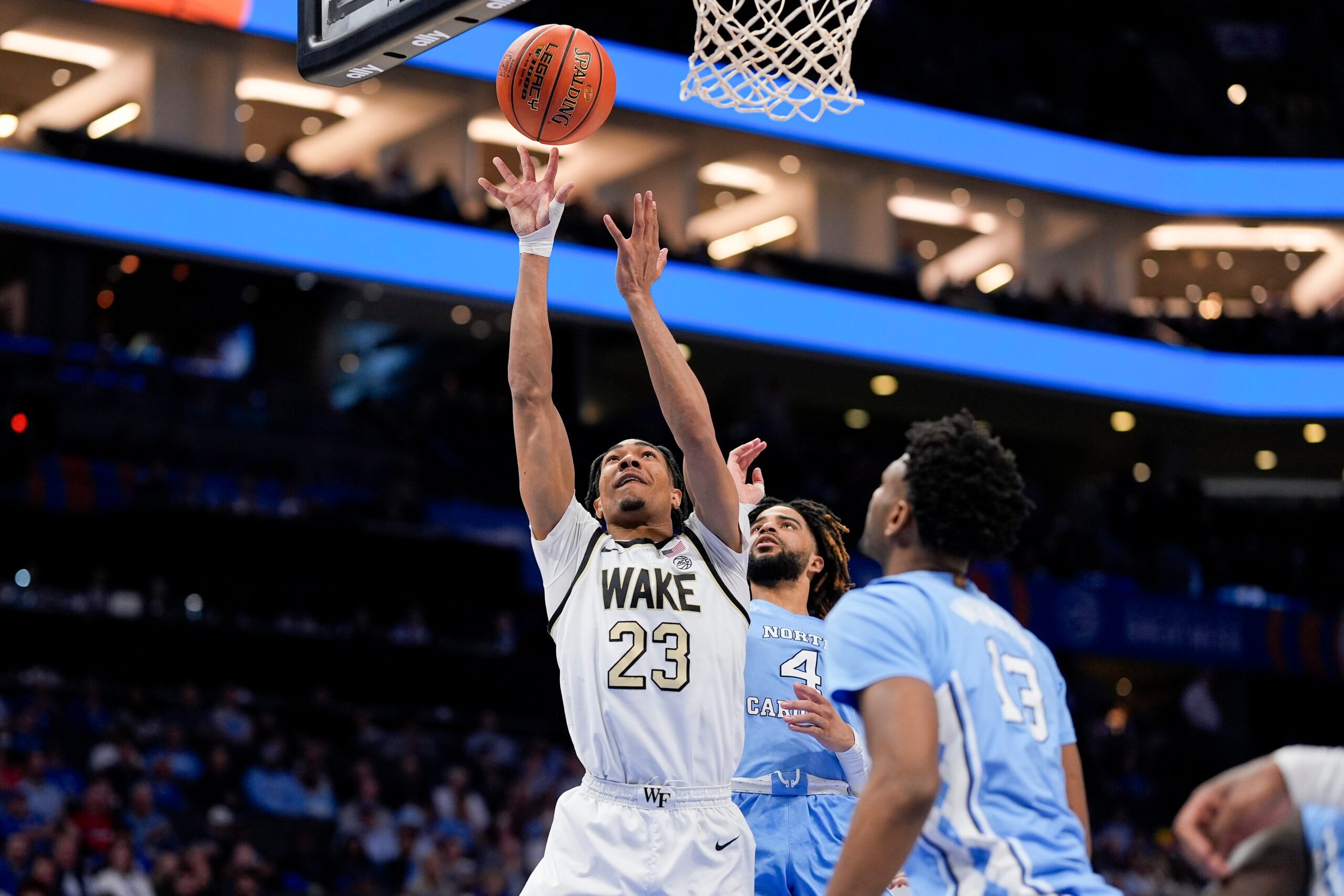 Mar 13, 2025; Charlotte, NC, USA; Wake Forest Demon Deacons guard Hunter Sallis (23) goes to the basket chased by North Carolina Tar Heels guard RJ Davis (4) during the second half at Spectrum Center. Mandatory Credit: Jim Dedmon-Imagn Images