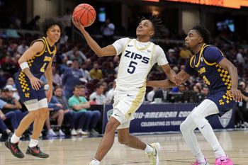 Akron Zips guard Tavari Johnson (5) looks to the basket ahead of Toledo Rockets guard Sonny Wilson (3) during the first half of an NCAA college basketball game in the semifinals of the Mid-American Conference Tournament at Rocket Arena on Friday, March 14, 2025, in Cleveland, Ohio.