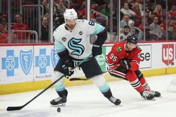 Mar 18, 2025; Chicago, Illinois, USA; Seattle Kraken defenseman Adam Larsson (6) and Chicago Blackhawks right wing Ilya Mikheyev (95) battle for control of the puck during the third period at United Center. Mandatory Credit: Talia Sprague-Imagn Images
