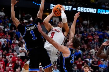 Mar 22, 2025; Denver, CO, USA; Wisconsin Badgers guard John Tonje (9) shoots the ball over Brigham Young Cougars guard Trey Stewart (1) during the second half in the second round of the NCAA Tournament  at Ball Arena. Mandatory Credit: Ron Chenoy-Imagn Images