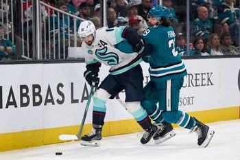 Apr 5, 2025; San Jose, California, USA; Seattle Kraken center Matty Beniers (10) controls the puck against San Jose Sharks defenseman Mario Ferraro (38) during the third period at SAP Center at San Jose. Mandatory Credit: Robert Edwards-Imagn Images