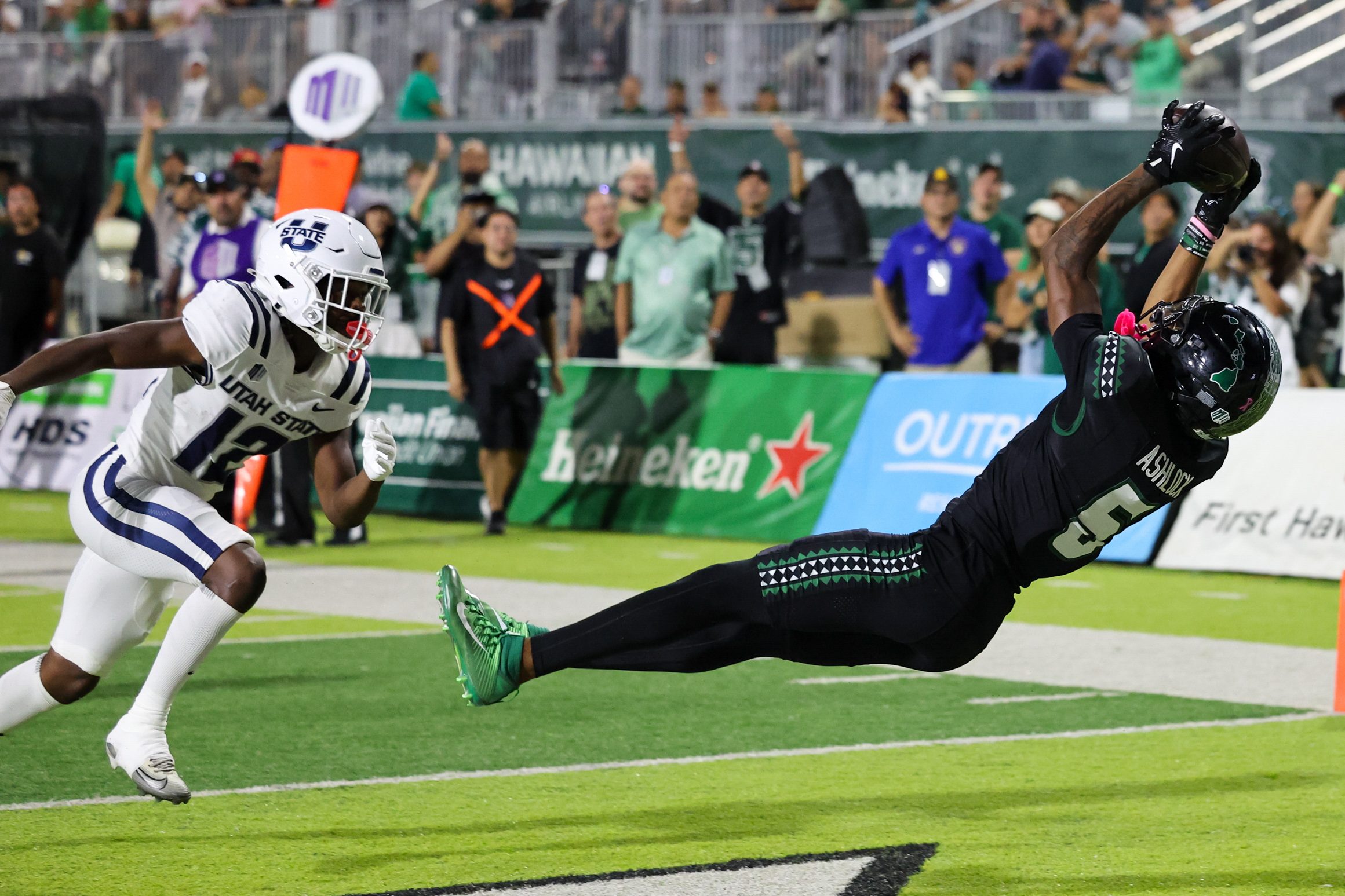Oct 11, 2025; Honolulu, Hawaii, USA;  Hawaii Rainbow Warriors wide receiver Pofele Ashlock (5) pulls in a touchdown catch over Utah State Aggies safety Bobby Arnold (12) during the first half at Clarence T.C. Ching Athletics Complex. Mandatory Credit: Marco Garcia-Imagn Images