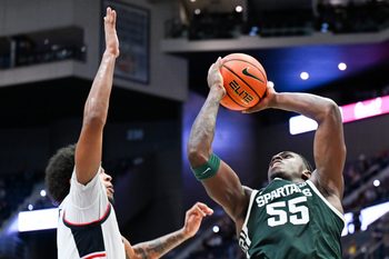 Oct 28, 2025; Hartford, CT, USA; Michigan State Spartans forward Coen Carr (55) shoots the ball against Connecticut Huskies forward Jayden Ross (23) during the second half at PeoplesBank Arena. Mandatory Credit: Mark Smith-Imagn Images
