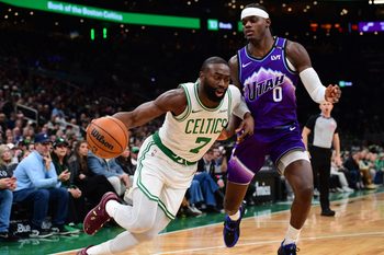 Nov 3, 2025; Boston, Massachusetts, USA; Boston Celtics guard Jaylen Brown (7) controls the ball while Utah Jazz forward Taylor Hendricks (0) defends during the first half at TD Garden. Mandatory Credit: Bob DeChiara-Imagn Images