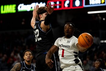 Cincinnati Bearcats guard Day Day Thomas (1) passes around Georgia State Panthers center Christian Beam (32) in the first half of the NCAA basketball game at Fifth Third Arena in Cincinnati on Nov. 7, 2025.