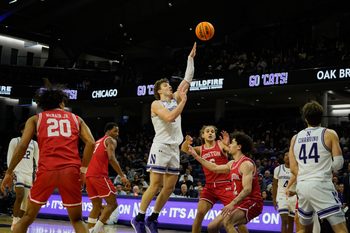 Nov 7, 2025; Evanston, Illinois, USA; Northwestern Wildcats forward Nick Martinelli (2) shoots the ball against Boston University Terriers guard Chance Gladden (2) during the first half at Welsh-Ryan Arena. Mandatory Credit: David Banks-Imagn Images
