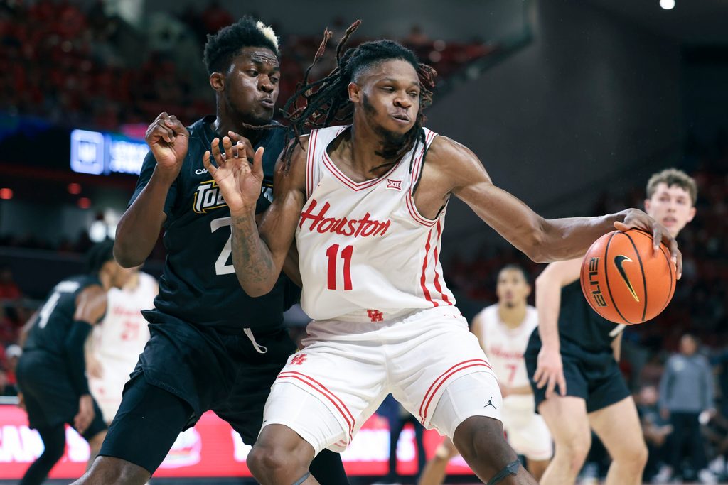 Nov 8, 2025; Houston, Texas, USA; Houston Cougars forward Joseph Tugler (11) attempts to control the ball as Towson Tigers forward Caleb Embeya (23) defends during the second half at Fertitta Center. Mandatory Credit: Troy Taormina-Imagn Images