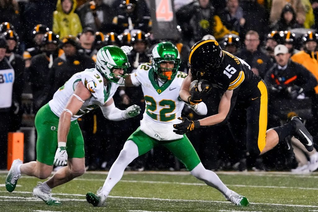 Iowa Hawkeyes wide receiver Reece Vander Zee (15) is stopped by Oregon Ducks defensive back Dillon Thieneman (31) and Oregon Ducks defensive back Jadon Canady (22) Nov. 8, 2025 during a Big Ten Football game at Kinnick Stadium in Iowa City, Iowa.