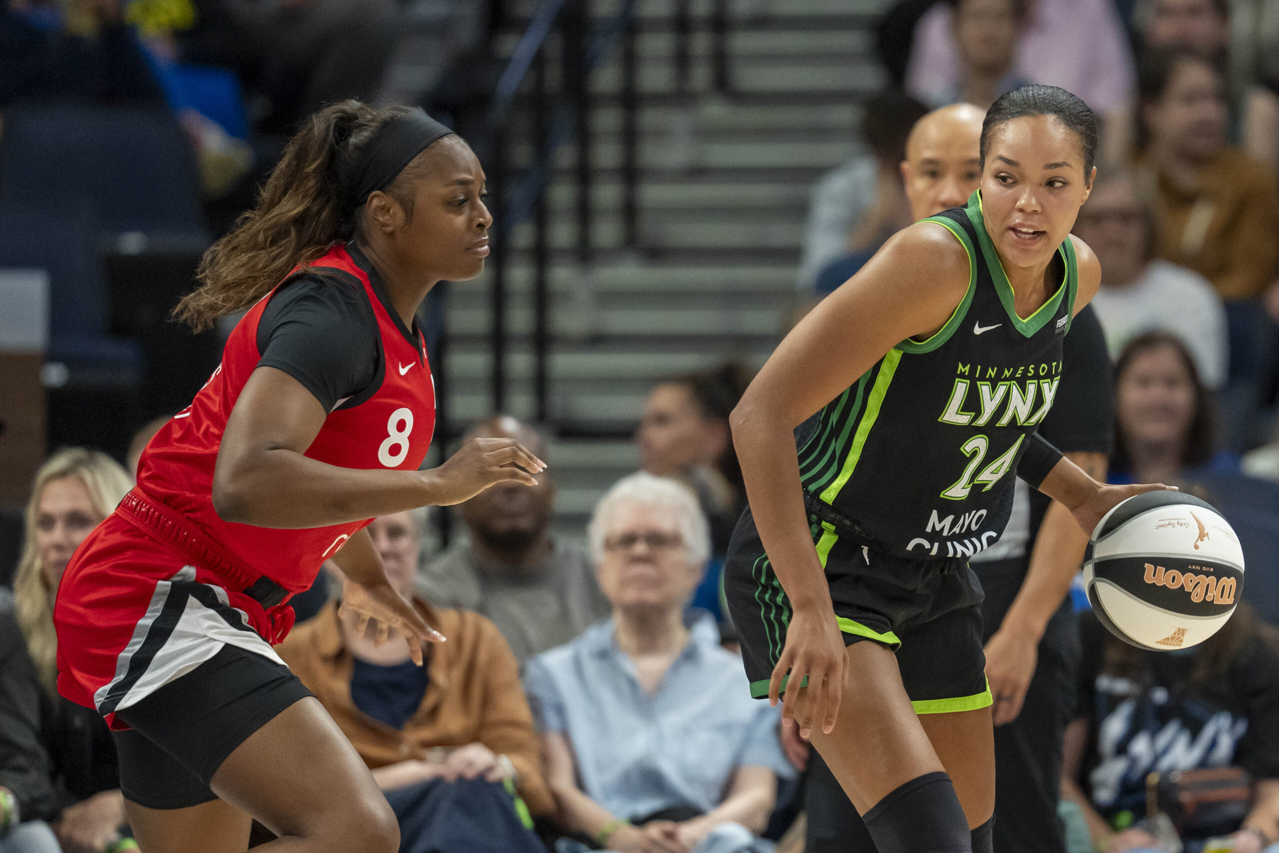 Jun 17, 2025; Minneapolis, Minnesota, USA; Minnesota Lynx forward Napheesa Collier (24) backs towards the basket as Las Vegas Aces forward Joyner Holmes (8) plays defense in the first half at Target Center. Mandatory Credit: Jesse Johnson-Imagn Images