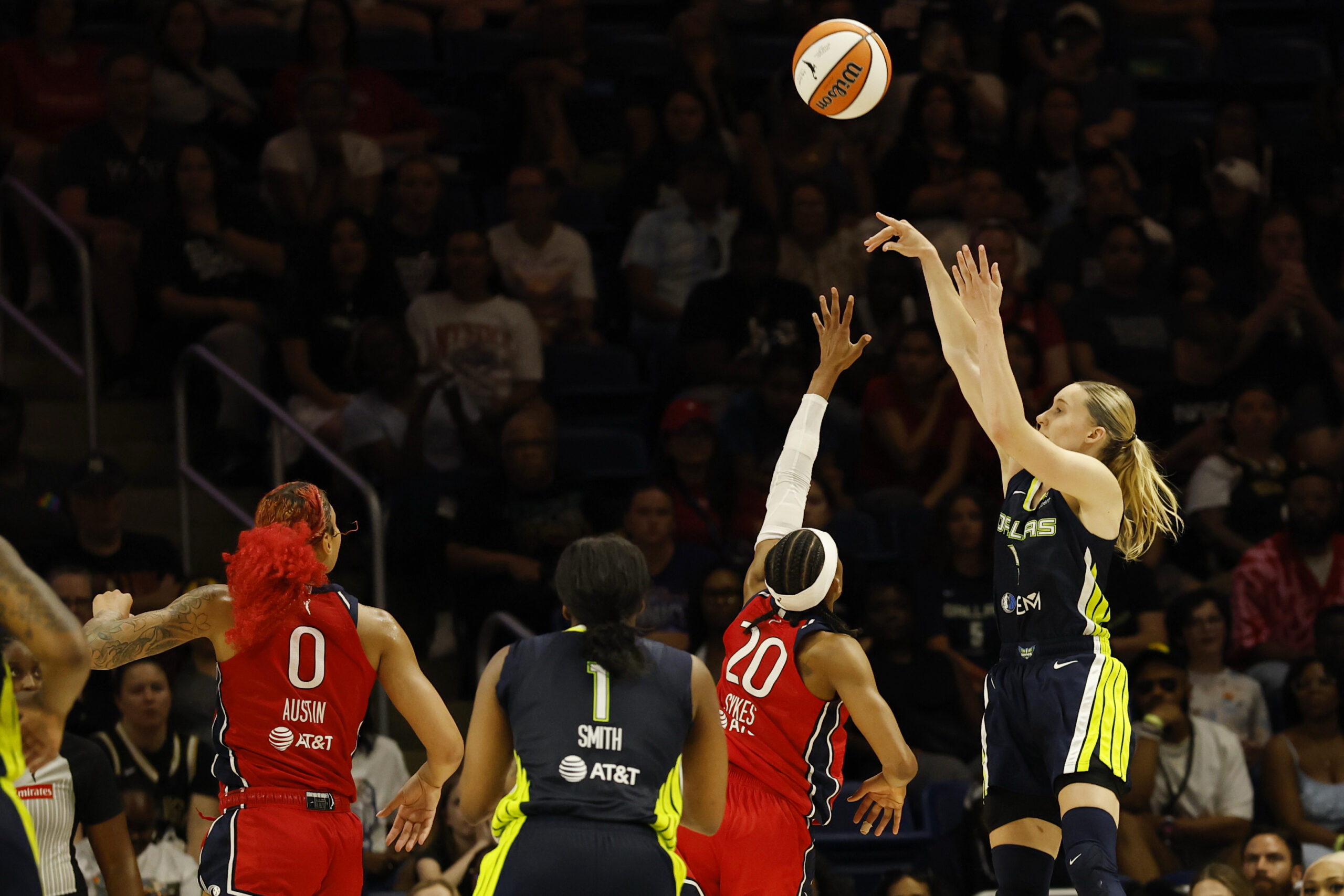 Jun 22, 2025; Washington, District of Columbia, USA; Dallas Wings guard Paige Bueckers (5) shoots the ball as Washington Mystics guard Brittney Sykes (20) defends in the second half at Entertainment & Sports Arena. Mandatory Credit: Geoff Burke-Imagn Images
