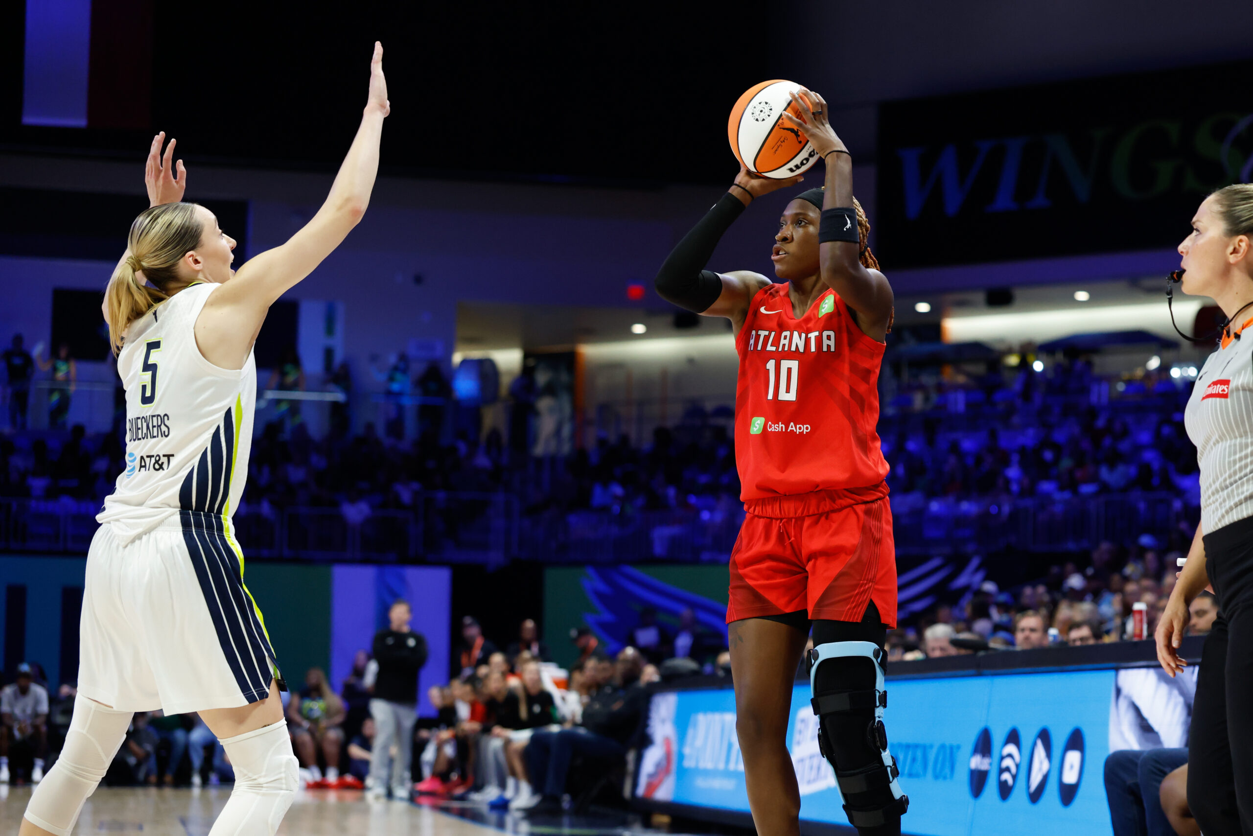 Jun 24, 2025; Arlington, Texas, USA; Atlanta Dream guard Rhyne Howard (10) scores a three-point basket against Dallas Wings guard Paige Bueckers (5) during the first half at College Park Center. Mandatory Credit: Chris Jones-Imagn Images