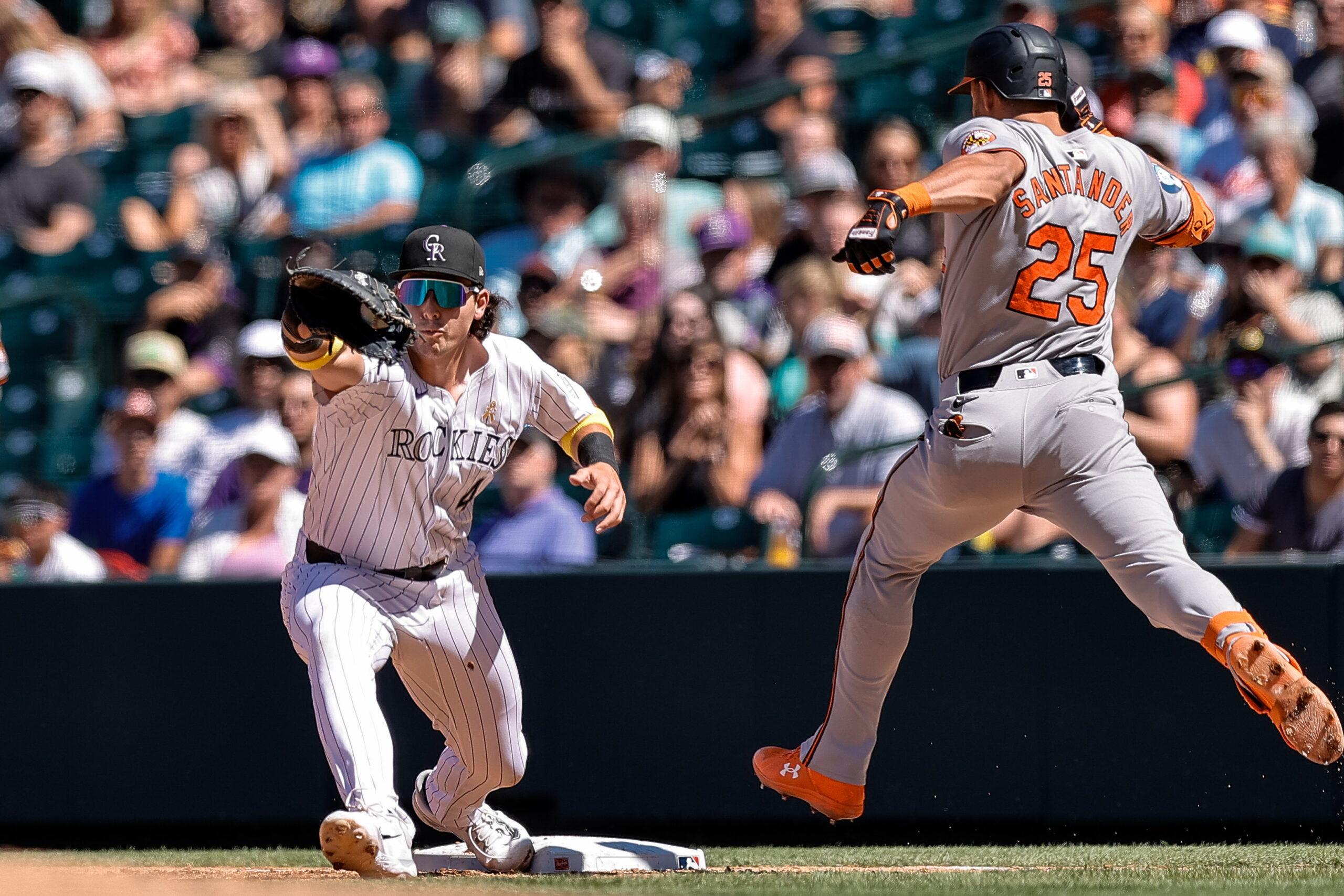 Sep 1, 2024; Denver, Colorado, USA; Baltimore Orioles right fielder Anthony Santander (25) is thrown out at first against Colorado Rockies first baseman Michael Toglia (4) in the fifth inning at Coors Field. Mandatory Credit: Isaiah J. Downing-Imagn Images
