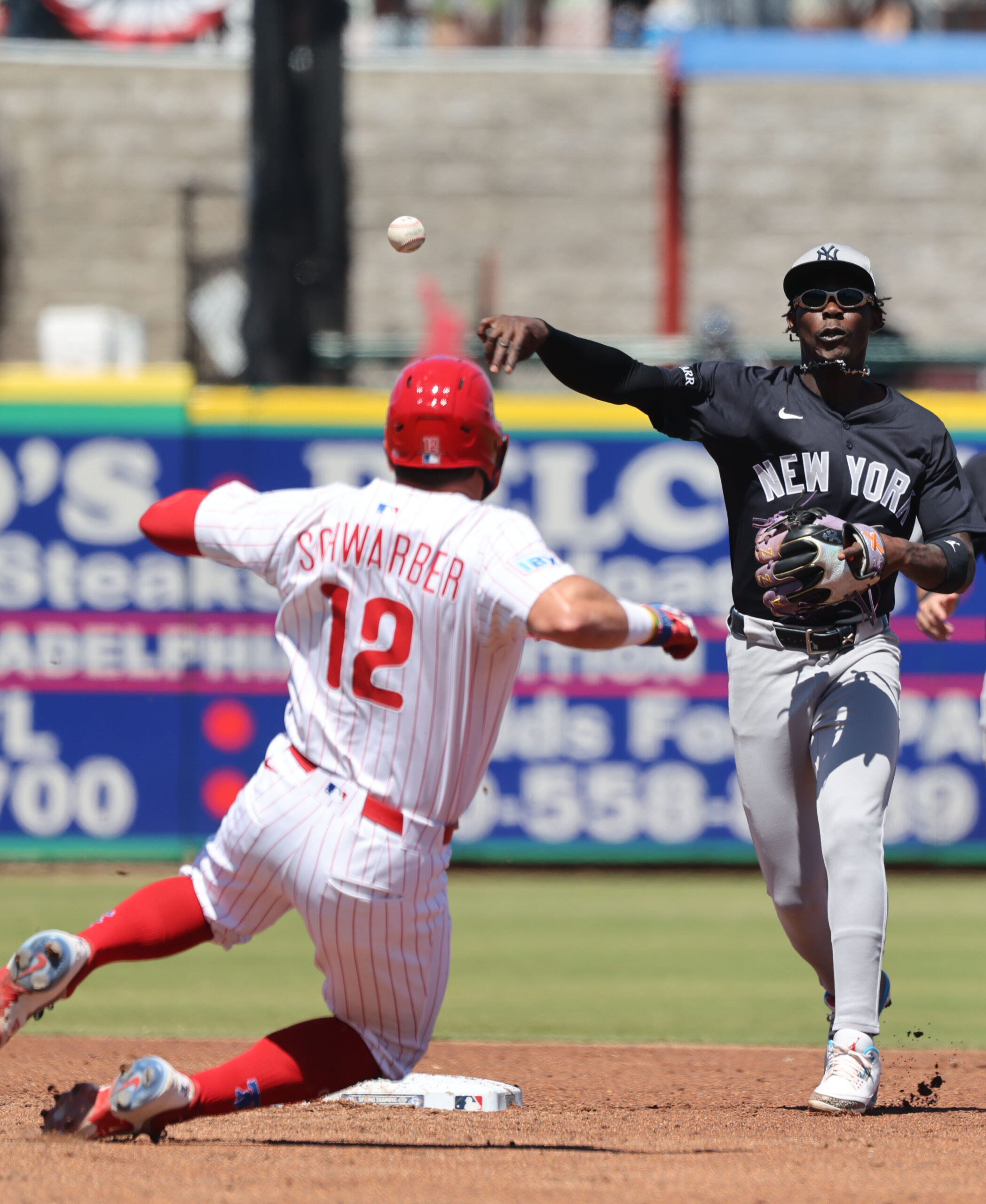 Mar 19, 2025; Clearwater, Florida, USA;  New York Yankees third base Jazz Chisholm Jr. (13) forces out Philadelphia Phillies designated hitter Kyle Schwarber (12) and throws the ball to first base for a double play during the third inning at BayCare Ballpark. Mandatory Credit: Kim Klement Neitzel-Imagn Images