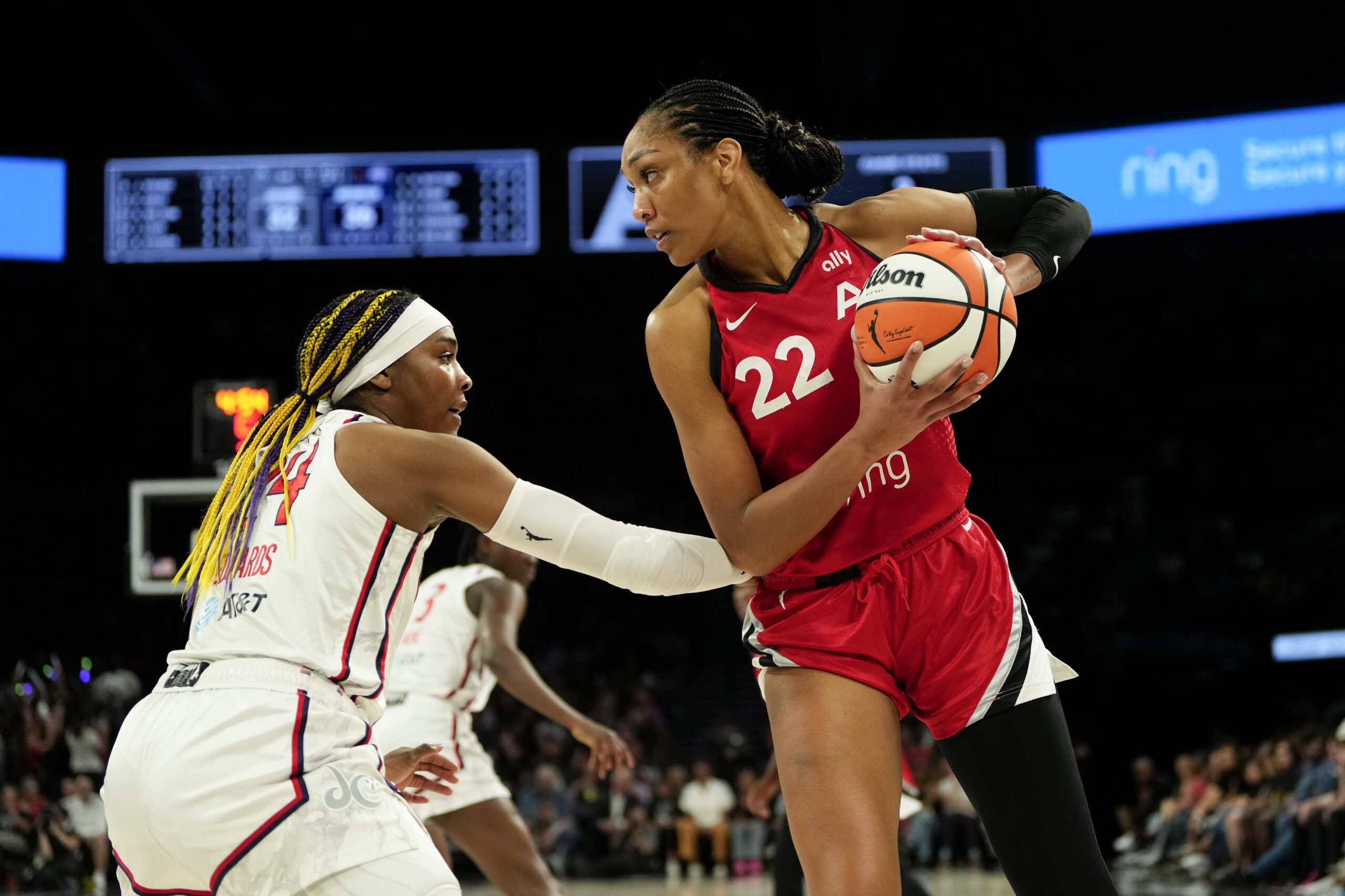 Jun 26, 2025; Las Vegas, Nevada, USA; Las Vegas Aces center A'ja Wilson (22) controls the ball against Washington Mystics forward Aaliyah Edwards (24) during the first half of a WNBA basketball game at Michelob Ultra Arena. Mandatory Credit: Lucas Peltier-Imagn Images