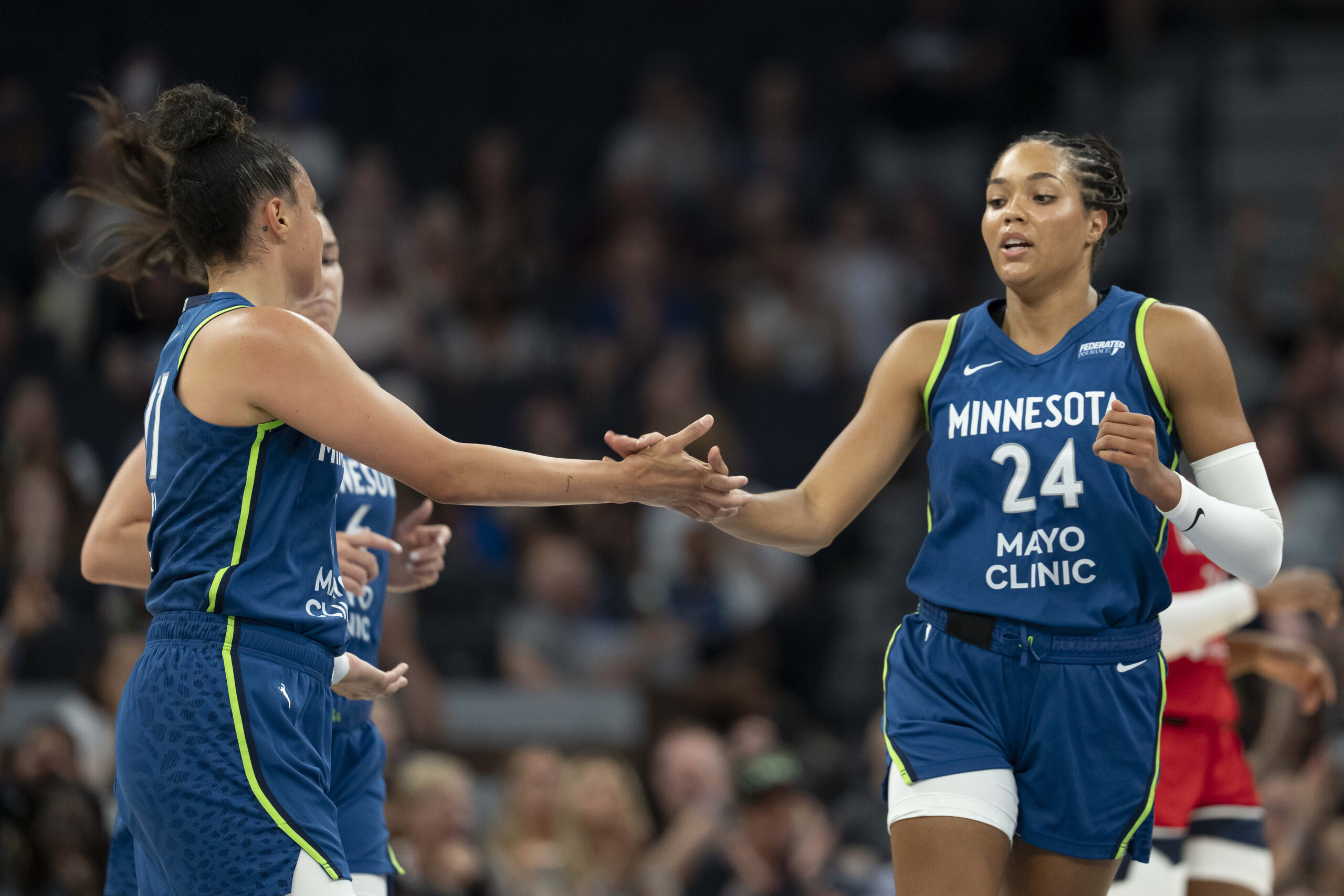Jul 3, 2025; Minneapolis, Minnesota, USA; Minnesota Lynx forward Napheesa Collier (24) shakes hands with Minnesota Lynx guard Kayla McBride (21) after making a shot against the Washington Mystics in the first half at Target Center. Mandatory Credit: Jesse Johnson-Imagn Images