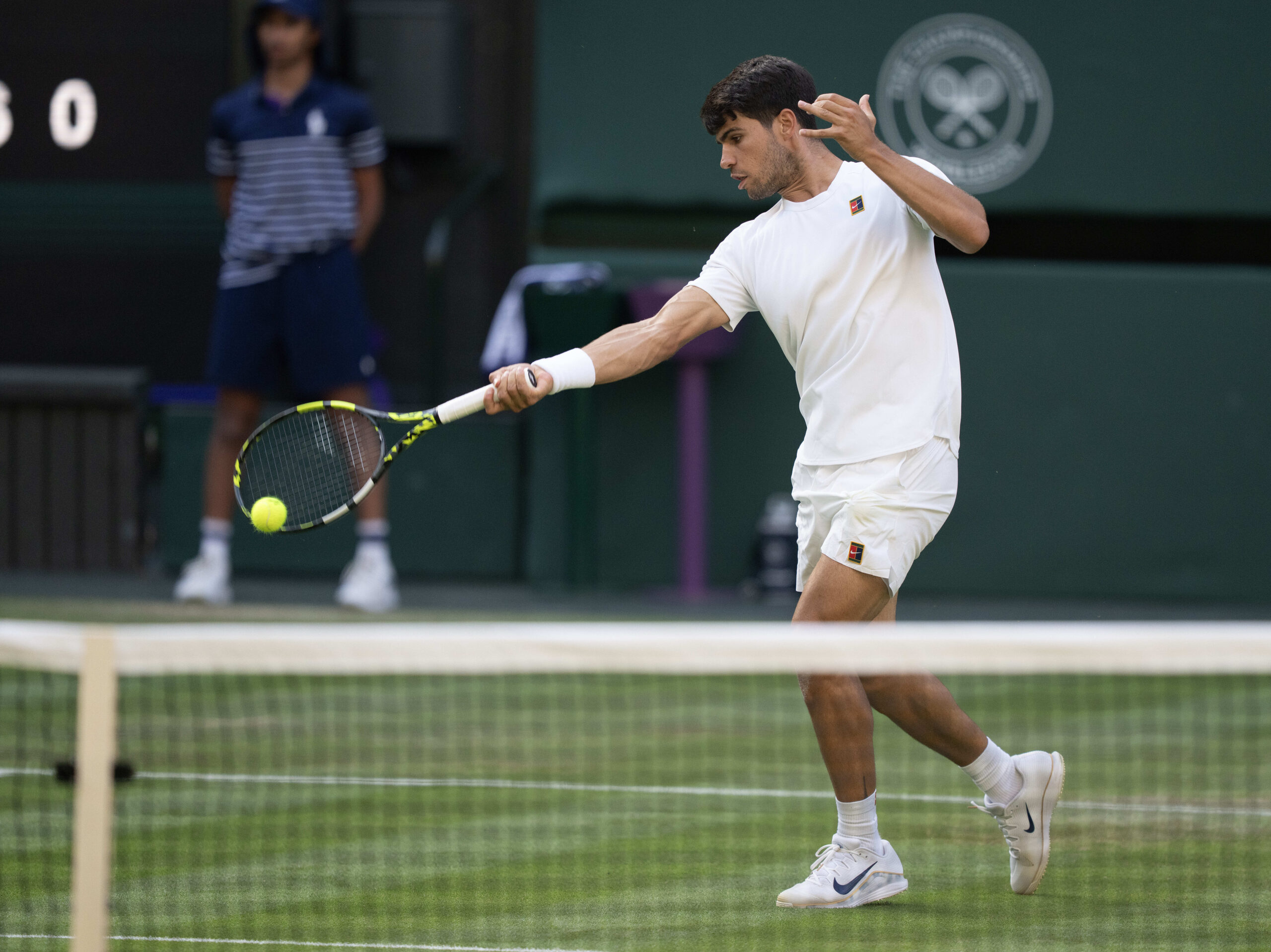 Jul 4, 2025; Wimbledon, United Kingdom; Carlos Alcaraz of Spain returns a shot during his match against Jan-Lennard Struff of Germany on day five at the All England Lawn Tennis and Croquet Club. Mandatory Credit: Susan Mullane-Imagn Images