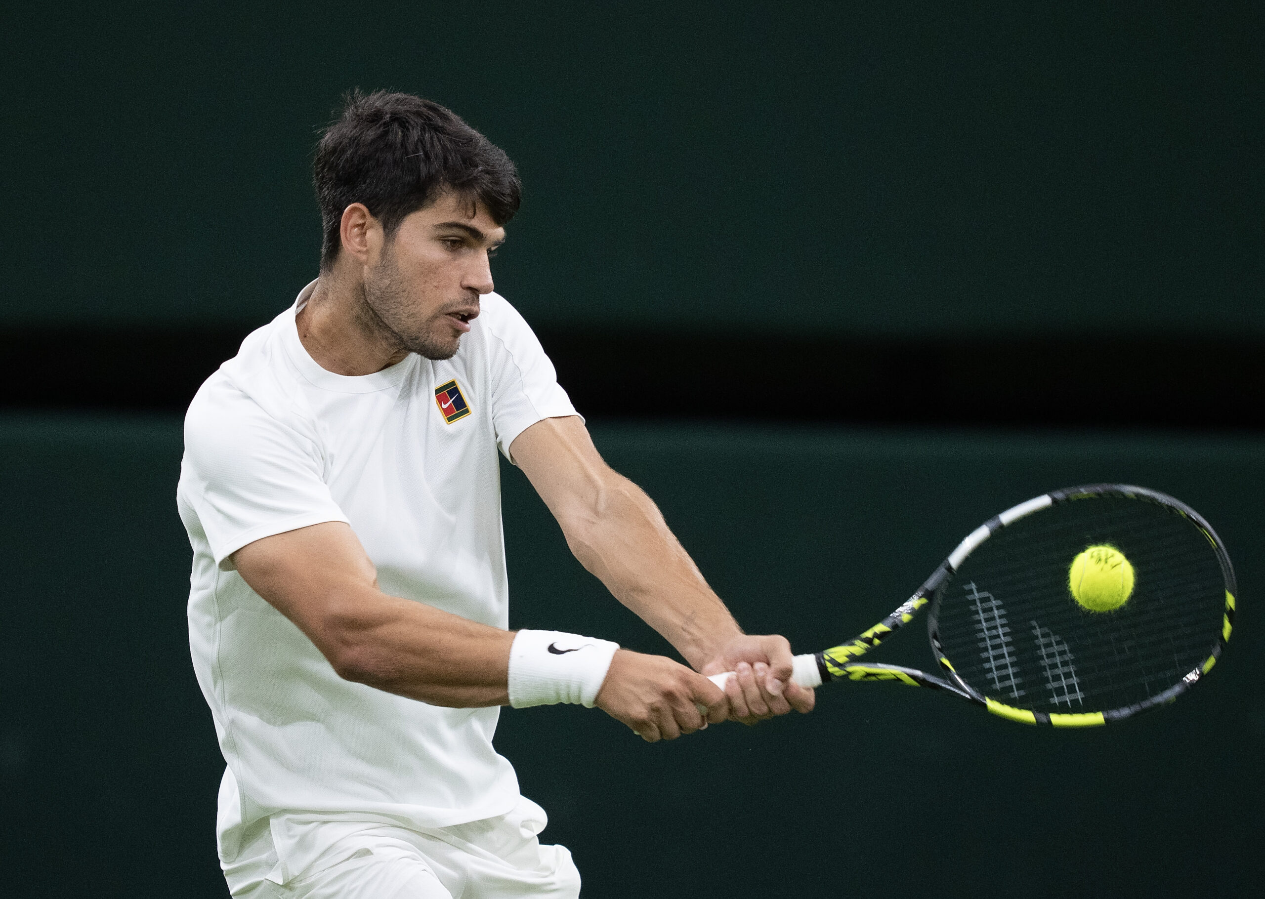 Jul 6, 2025; Wimbledon, United Kingdom; Carlos Alcaraz of Spain returns a shot during his match against Andrey Rublev on day seven at the All England Lawn Tennis and Croquet Club. Mandatory Credit: Susan Mullane-Imagn Images