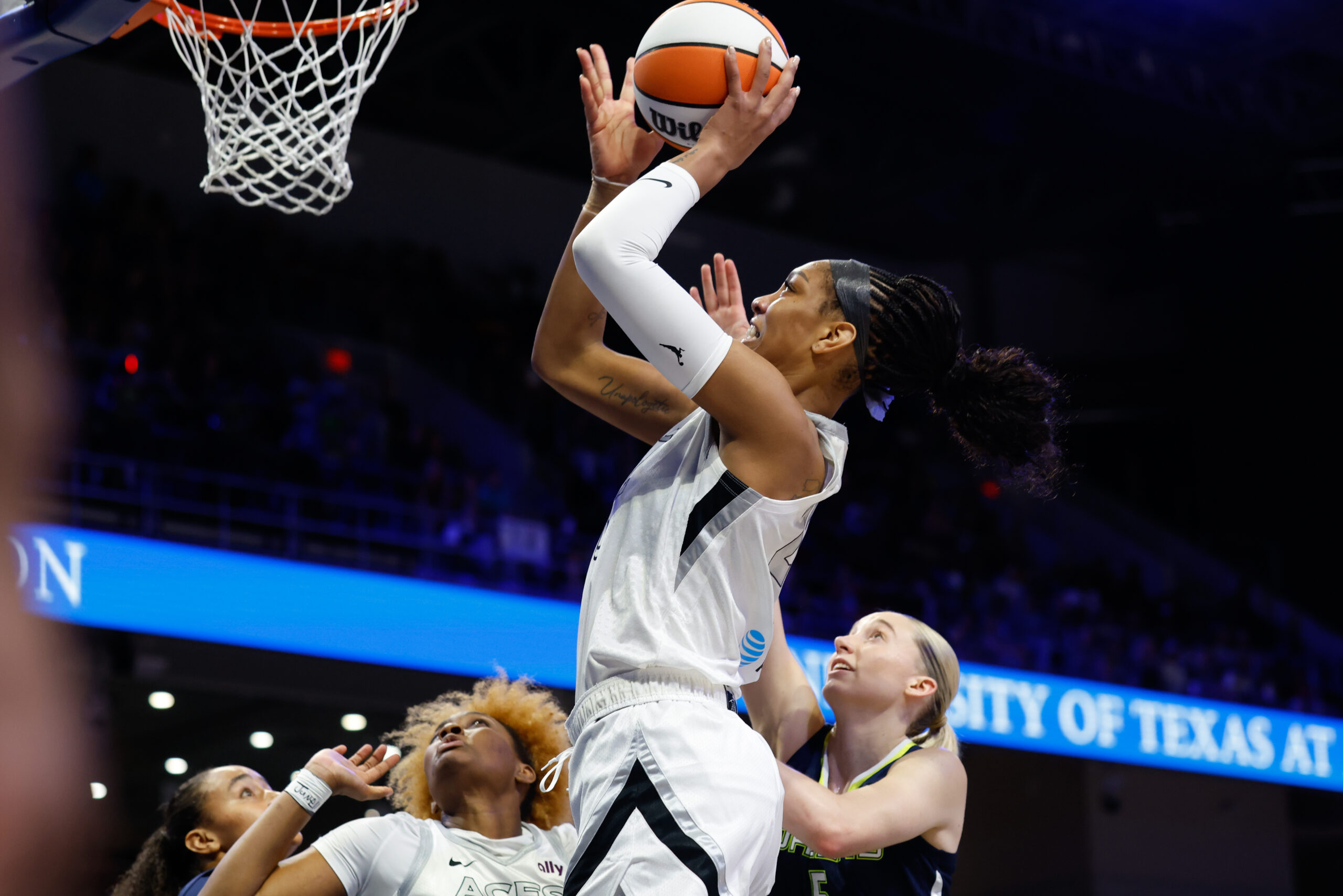 Jul 16, 2025; Arlington, Texas, USA;Las Vegas Aces center A'ja Wilson (22) scores a layup past Dallas Wings guard Paige Bueckers (5) during the first half at College Park Center. Mandatory Credit: Chris Jones-Imagn Images