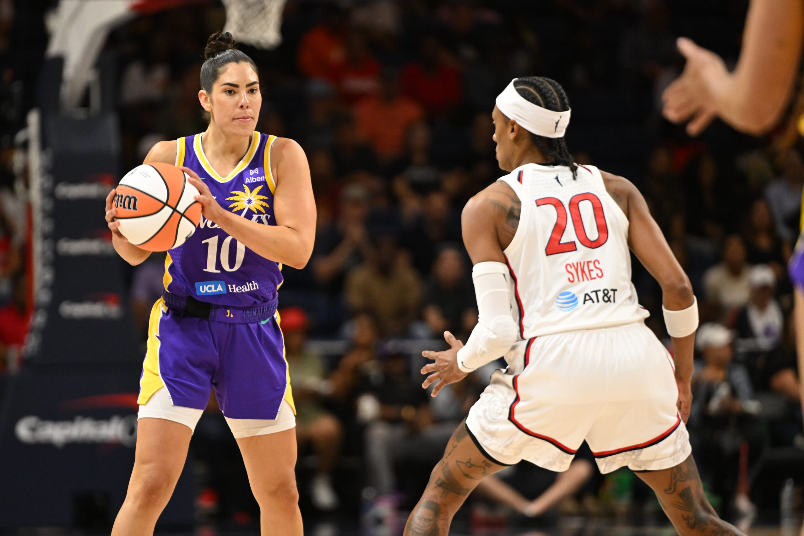 Jul 22, 2025; Washington, District of Columbia, USA; Los Angeles Sparks guard Kelsey Plum (10) looks to pass the ball in front of Washington Mystics guard Brittney Sykes (20) during the first quarter at CareFirst Arena. Mandatory Credit: Rafael Suanes-Imagn Images