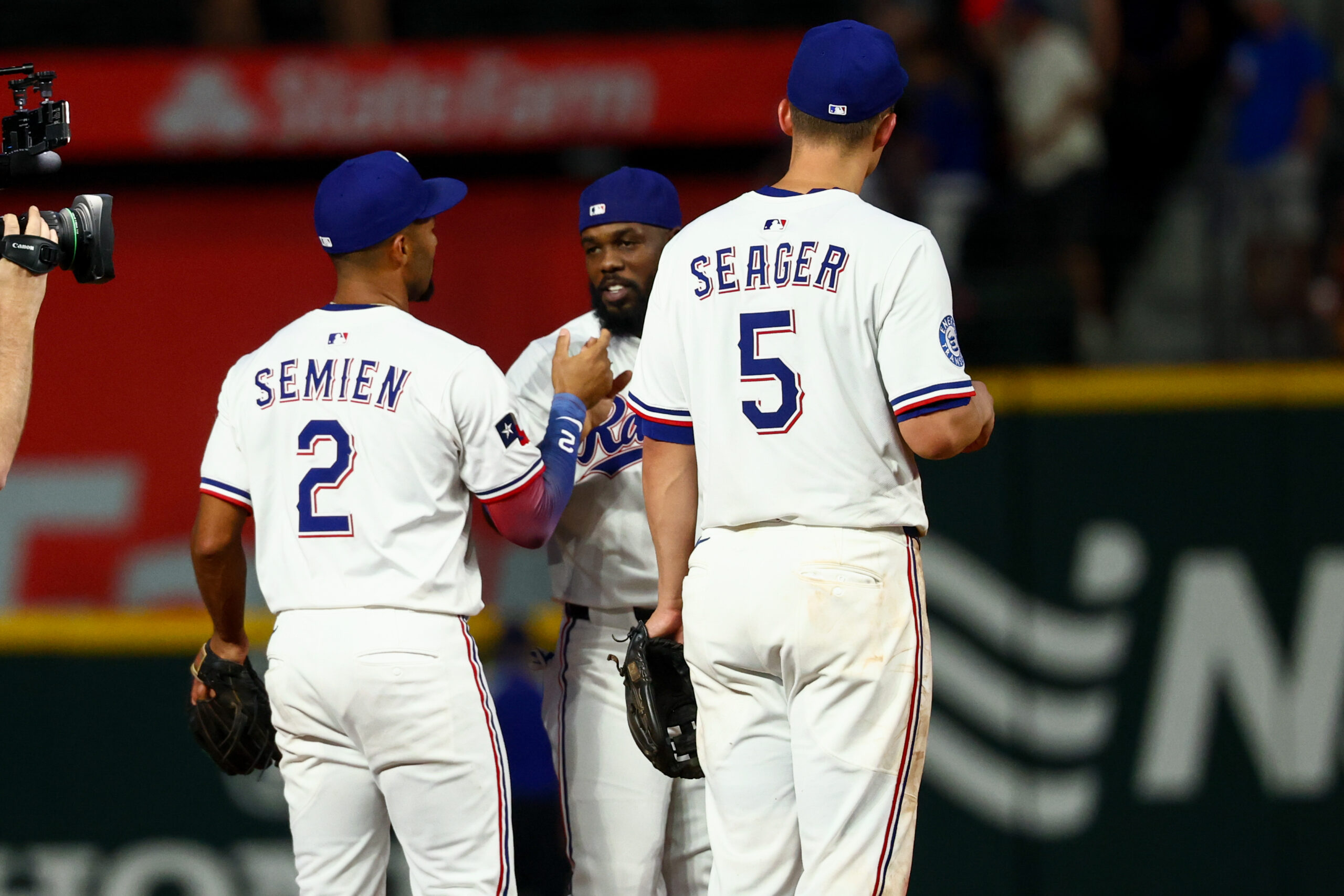 Jul 22, 2025; Arlington, Texas, USA;  Texas Rangers shortstop Corey Seager (5) celebrates with Texas Rangers second baseman Marcus Semien (2) and Texas Rangers right fielder Adolis Garcia (53) after the game against the Athletics at Globe Life Field. Mandatory Credit: Kevin Jairaj-Imagn Images