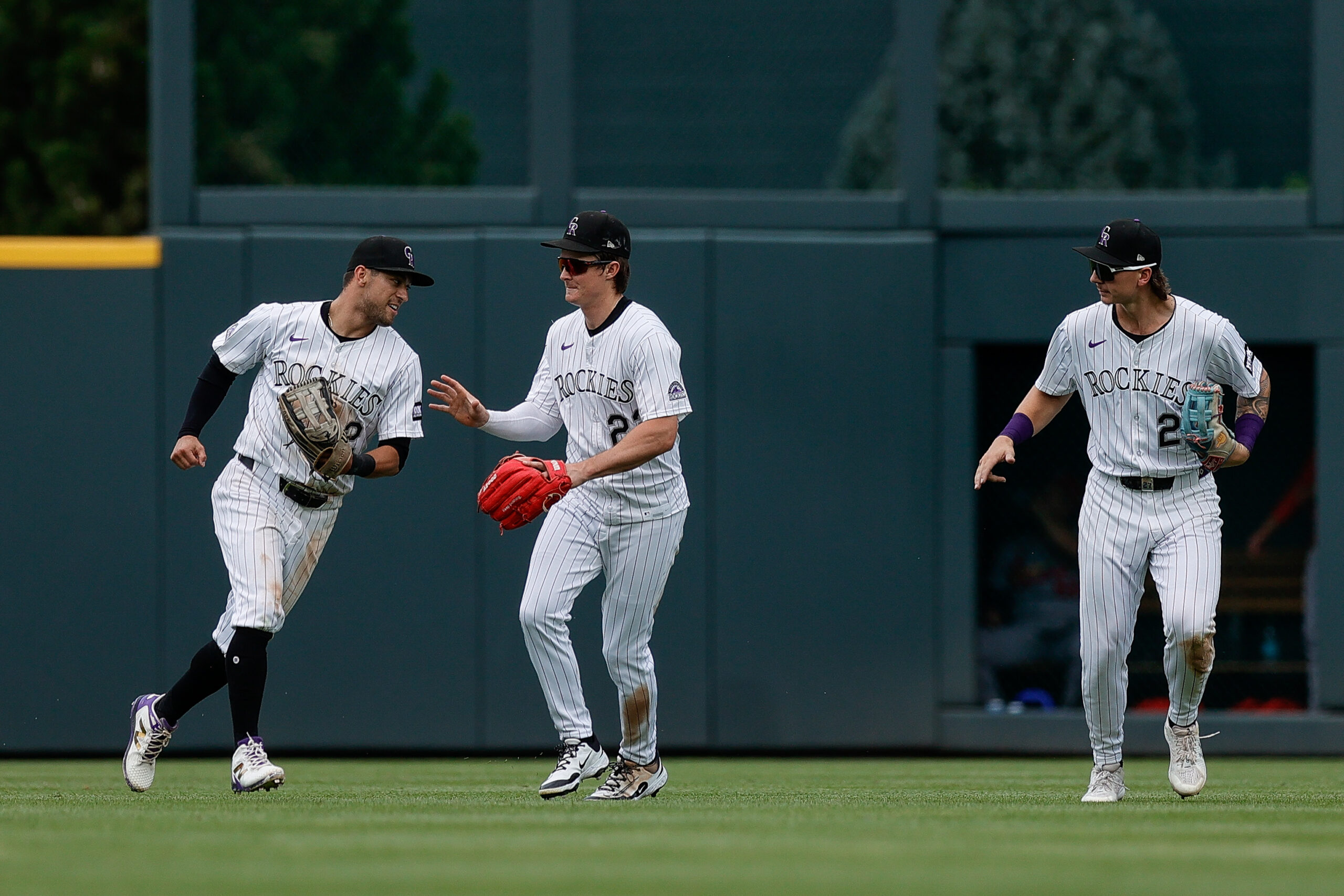 Jul 23, 2025; Denver, Colorado, USA; Colorado Rockies right fielder Tyler Freeman (2) and center fielder Mickey Moniak (22) and left fielder Jordan Beck (27) after the game against the St. Louis Cardinals at Coors Field. Mandatory Credit: Isaiah J. Downing-Imagn Images