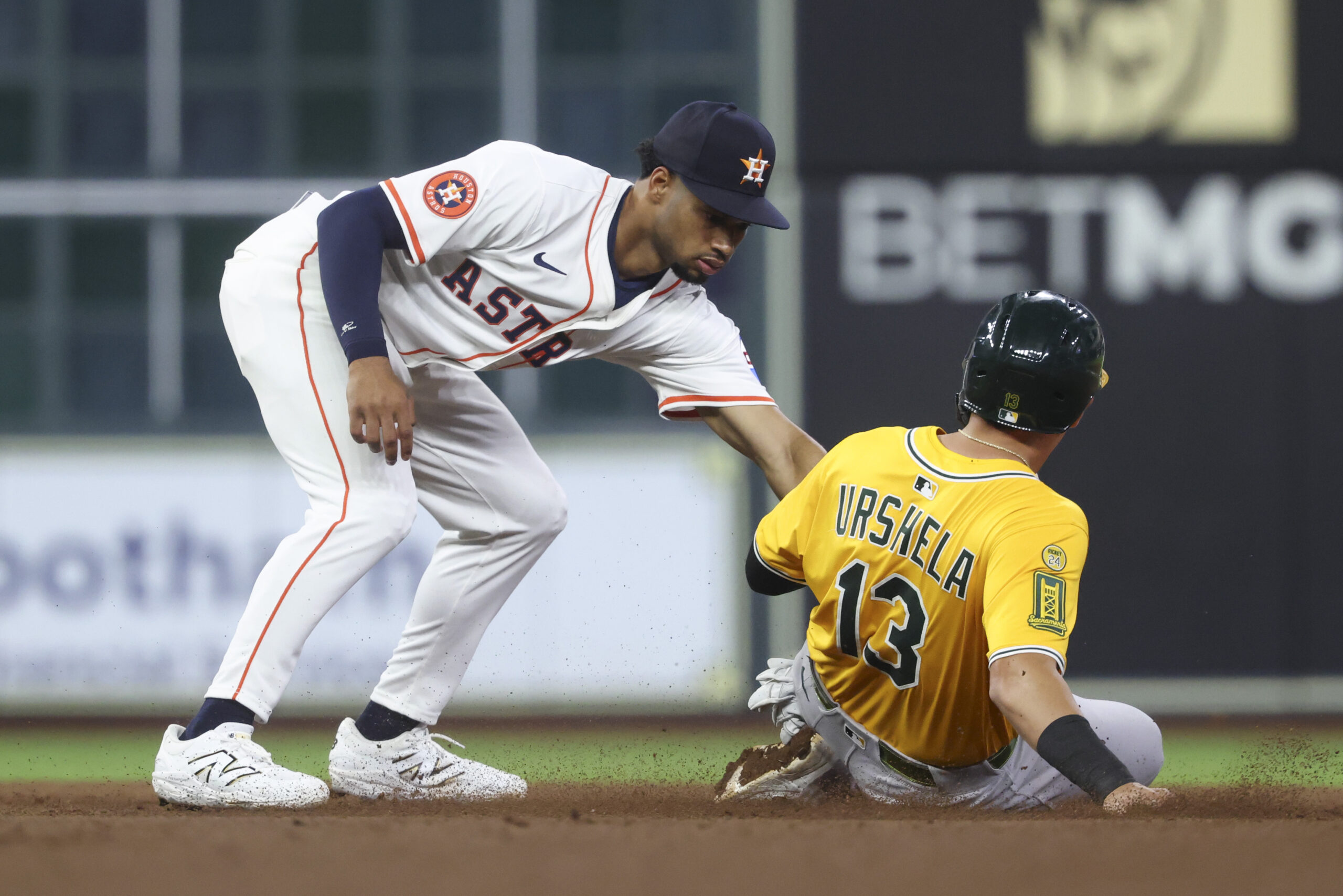 Jul 24, 2025; Houston, Texas, USA;  Athletics third baseman Gio Urshela (13) is out on a stolen base attempt as Houston Astros second baseman Brice Matthews (28) applies a tag during the eighth inning at Daikin Park. Mandatory Credit: Troy Taormina-Imagn Images