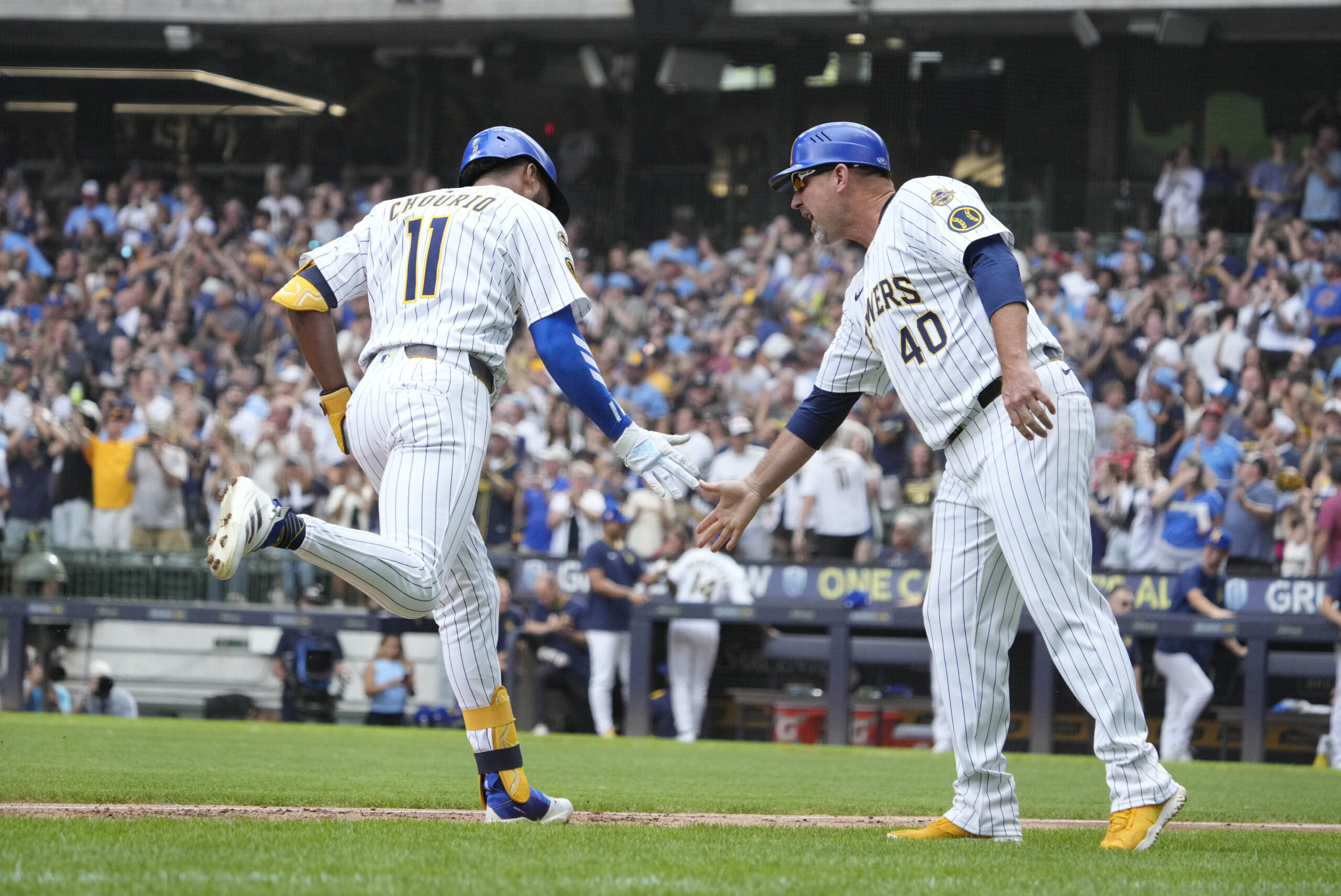 Jul 25, 2025; Milwaukee, Wisconsin, USA; Milwaukee Brewers outfielder Jackson Chourio (11) is congratulated by third base coach Jason Lane (40) while rounding the bases after hitting a home run against the Miami Marlins in the fourth at American Family Field. Mandatory Credit: Michael McLoone-Imagn Images
