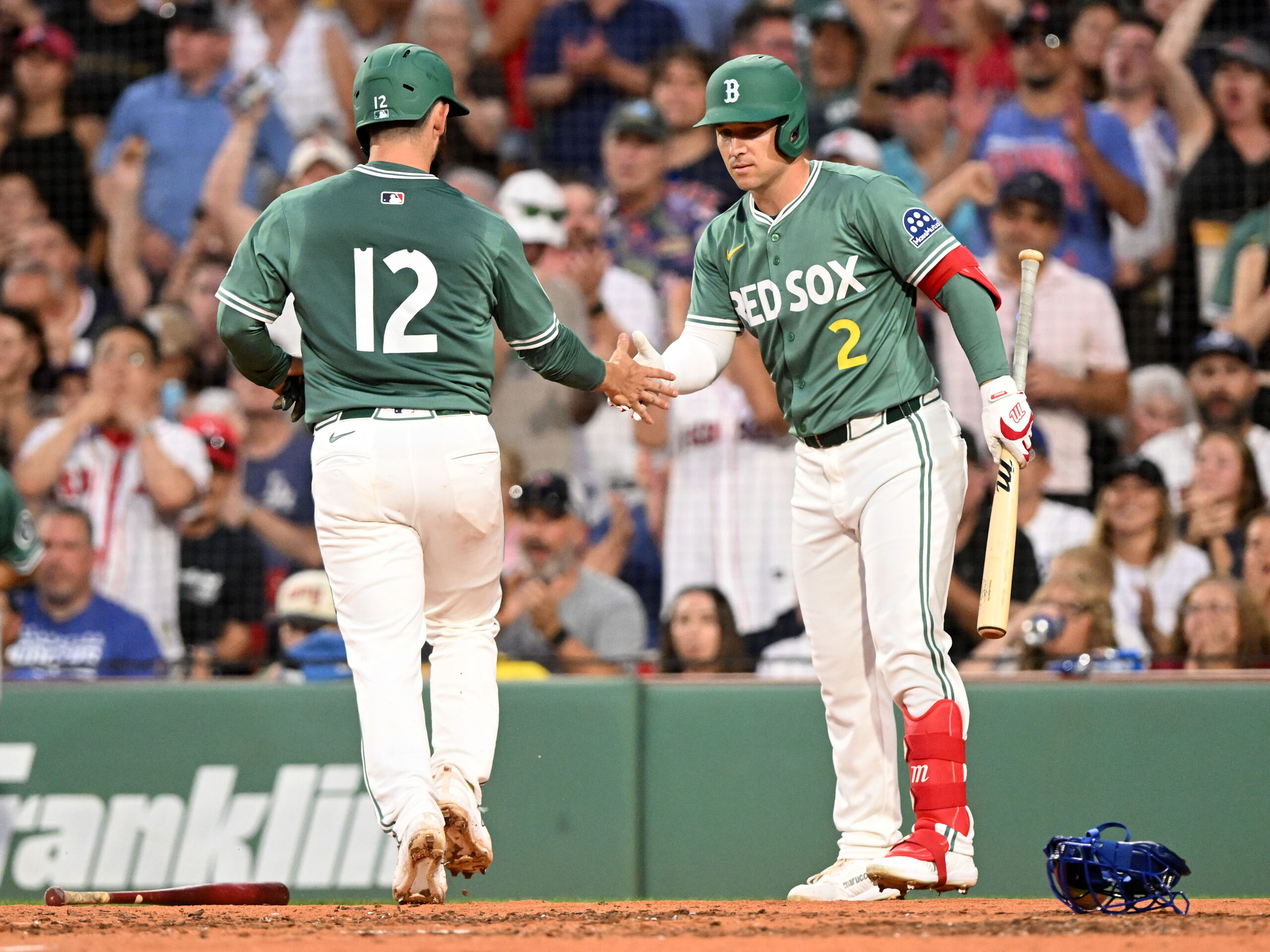 Jul 25, 2025; Boston, Massachusetts, USA; Boston Red Sox catcher Connor Wong (12) high-fives third baseman Alex Bregman (2) after scoring a run against the Los Angeles Dodgers during the third inning at Fenway Park. Mandatory Credit: Brian Fluharty-Imagn Images