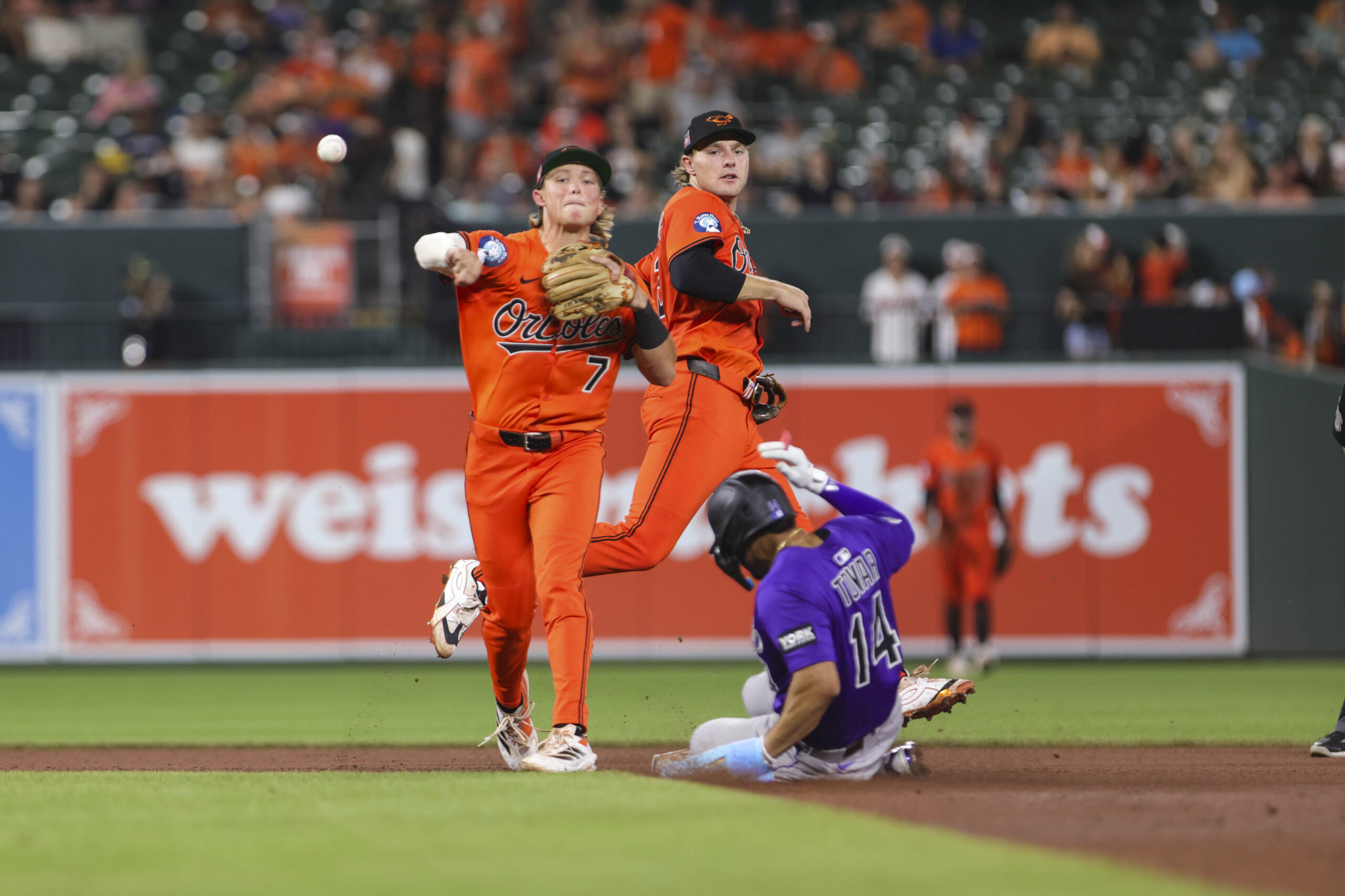 Jul 26, 2025; Baltimore, Maryland, USA; Baltimore Orioles’ second Baseman Jackson Holliday (7) turns a double play against the Colorado Rockies in the seventh inning  at Oriole Park at Camden Yards. Mandatory Credit: Lexi Thompson-Imagn Images