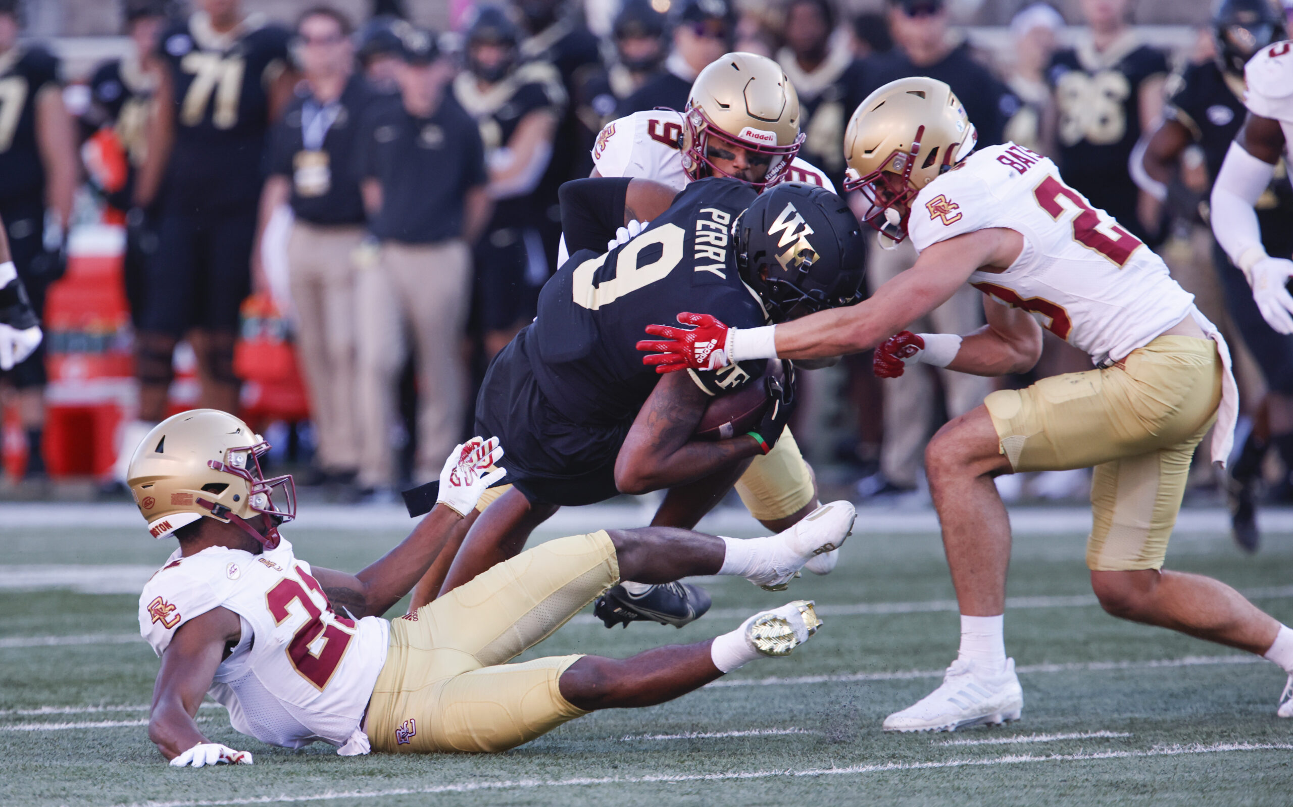 Oct 22, 2022; Winston-Salem, North Carolina, USA;  Boston College Eagles defensive back Josh DeBerry (bottom left) and defensive back Cole Batson (right) and defensive back Jaiden Woodbey (9) tackle Wake Forest Demon Deacons wide receiver A.T. Perry (9) during the second quarter at Truist Field. Mandatory Credit: Reinhold Matay-Imagn Images
