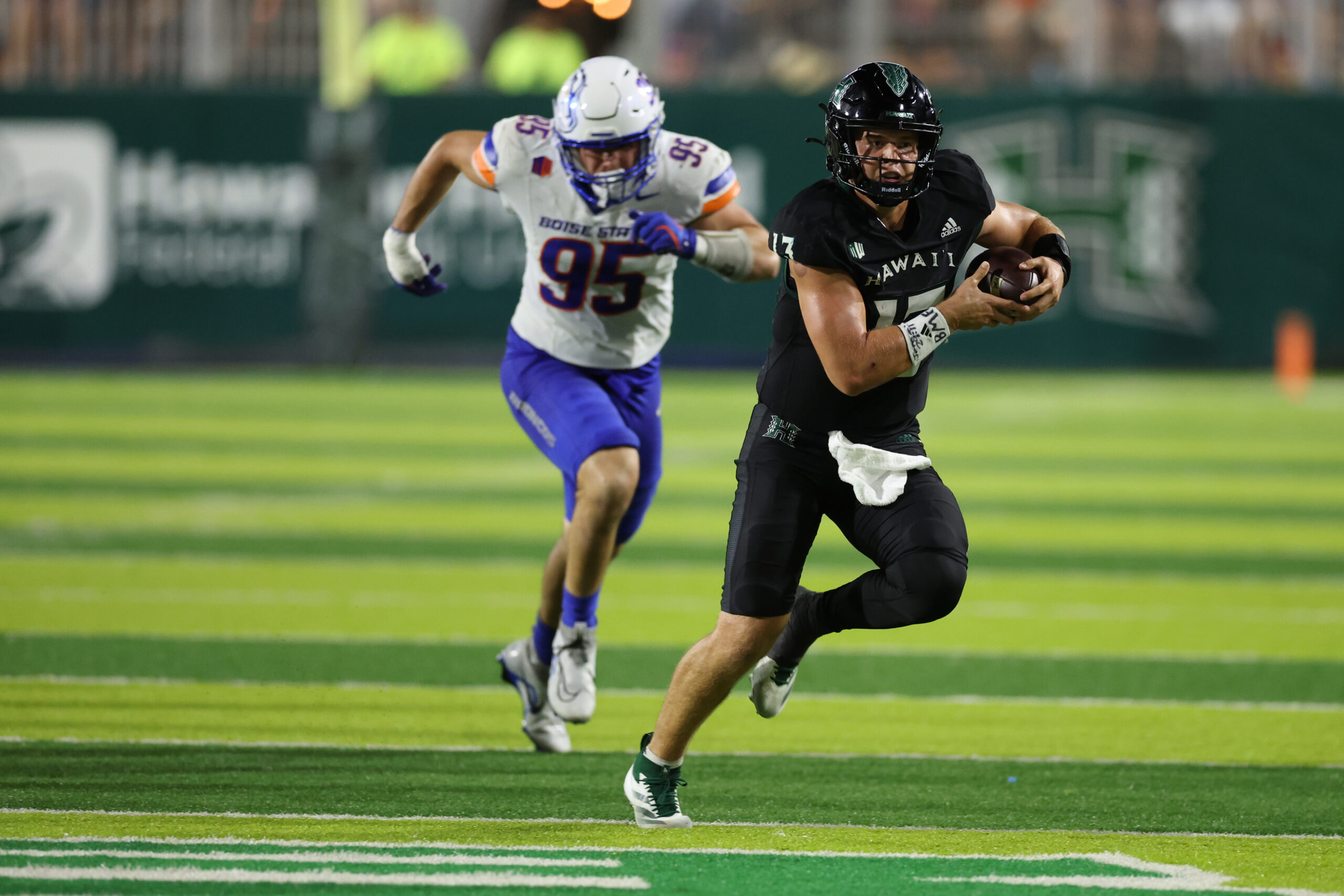 Oct 12, 2024; Honolulu, Hawaii, USA; Hawaii Rainbow Warriors quarterback Brayden Schager (13) gets chased down by Boise State Broncos defensive end Max Stege (95) during the fourth quarter of a NCAA college football game at Clarence T.C. Ching Athletics Complex. Mandatory Credit: Marco Garcia-Imagn Images