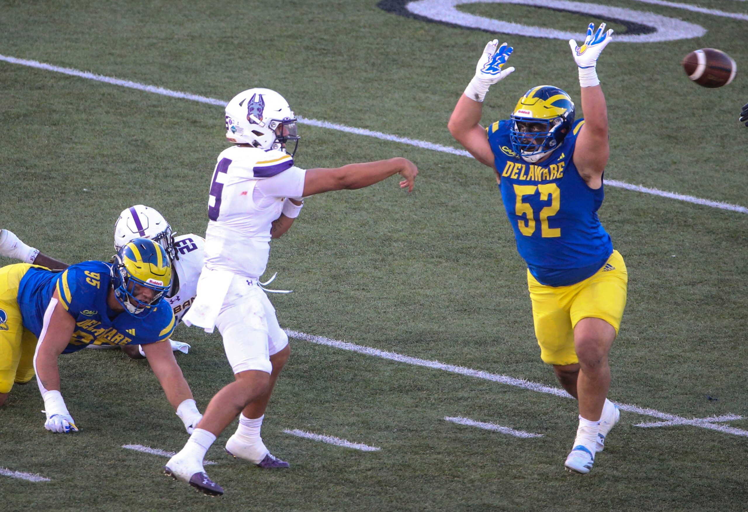 Albany quarterback Myles Burkett throws as Delaware's Melkart Abou-Jaoude (left) and Dominick Brogna close in during the third quarter of the Blue Hens' 28-14 win at Delaware Stadium, Saturday, Oct. 26, 2024.