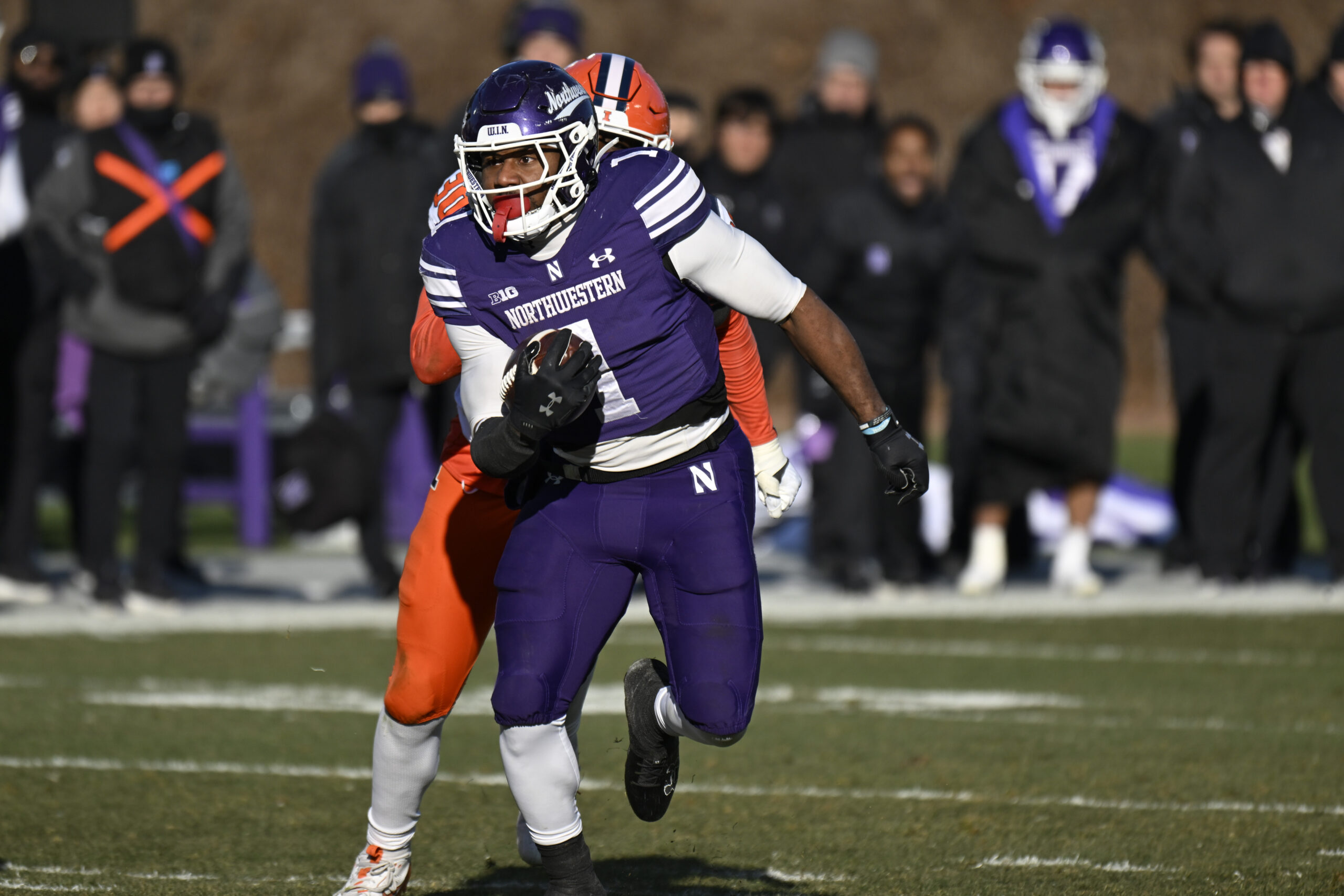 Nov 30, 2024; Chicago, Illinois, USA;  Northwestern Wildcats running back Cam Porter (1) runs the ball against the Illinois Fighting Illini during the second half at Wrigley Field. Mandatory Credit: Matt Marton-Imagn Images