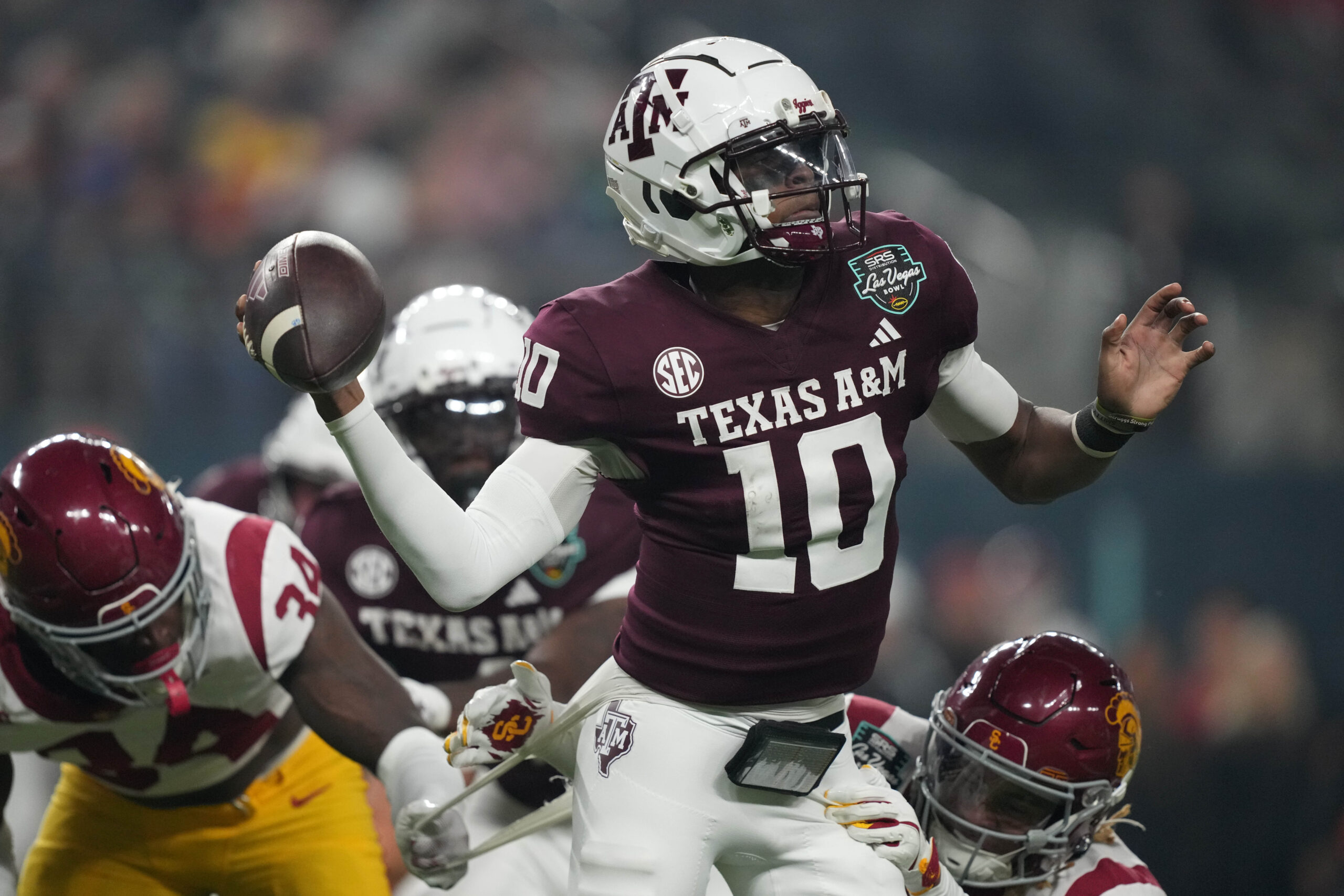 Dec 27, 2024; Las Vegas, NV, USA; Texas A&M Aggies quarterback Marcel Reed (10) throws the ball against Southern California Trojans cornerback John Humphrey (19) in the first half at Allegiant Stadium. Mandatory Credit: Kirby Lee-Imagn Images