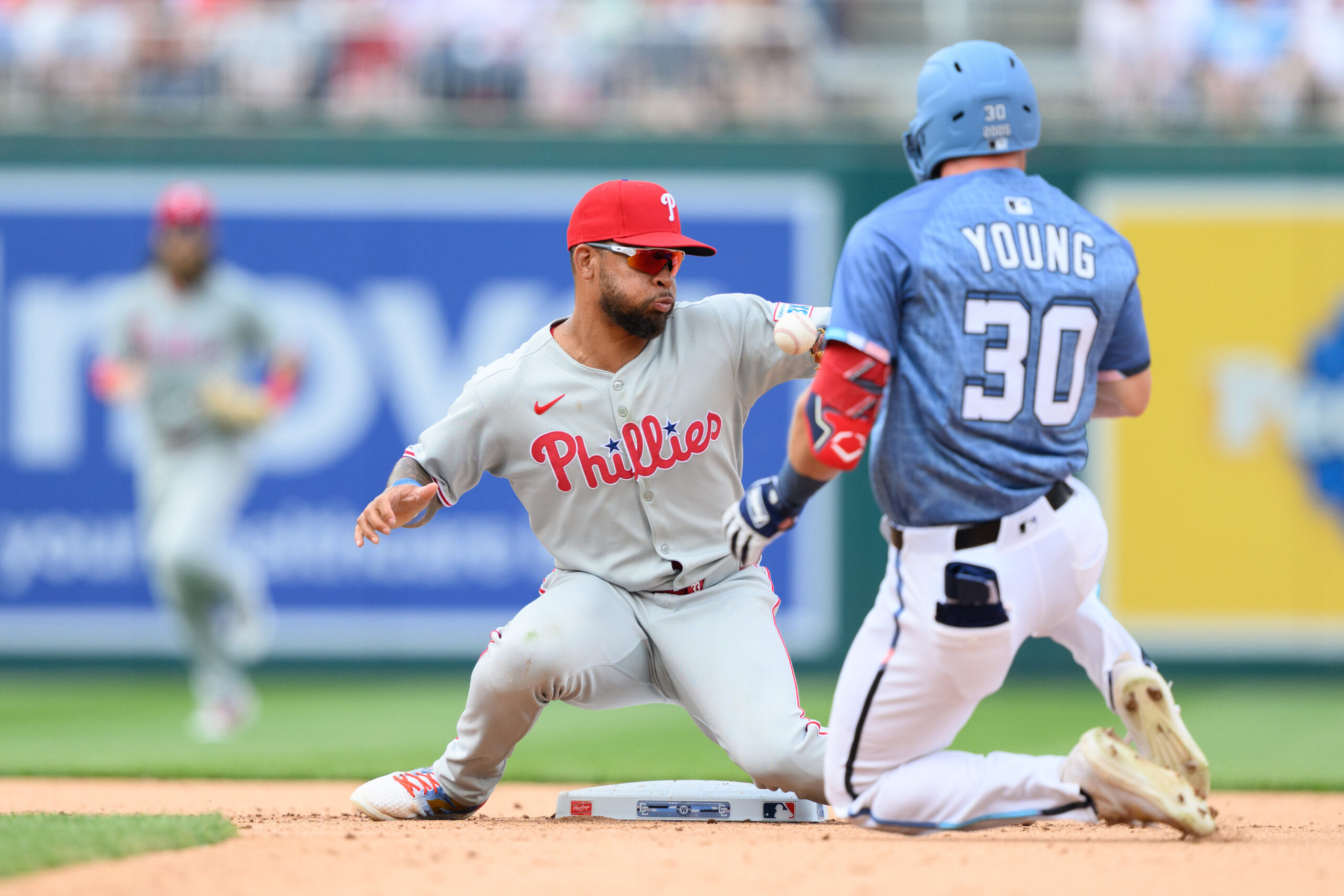 Mar 29, 2025; Washington, District of Columbia, USA; Philadelphia Phillies shortstop Edmundo Sosa (33) tops the ball as Washington Nationals outfielder Jacob Young (30) slides into second base during the eighth inning at Nationals Park. Mandatory Credit: Reggie Hildred-Imagn Images