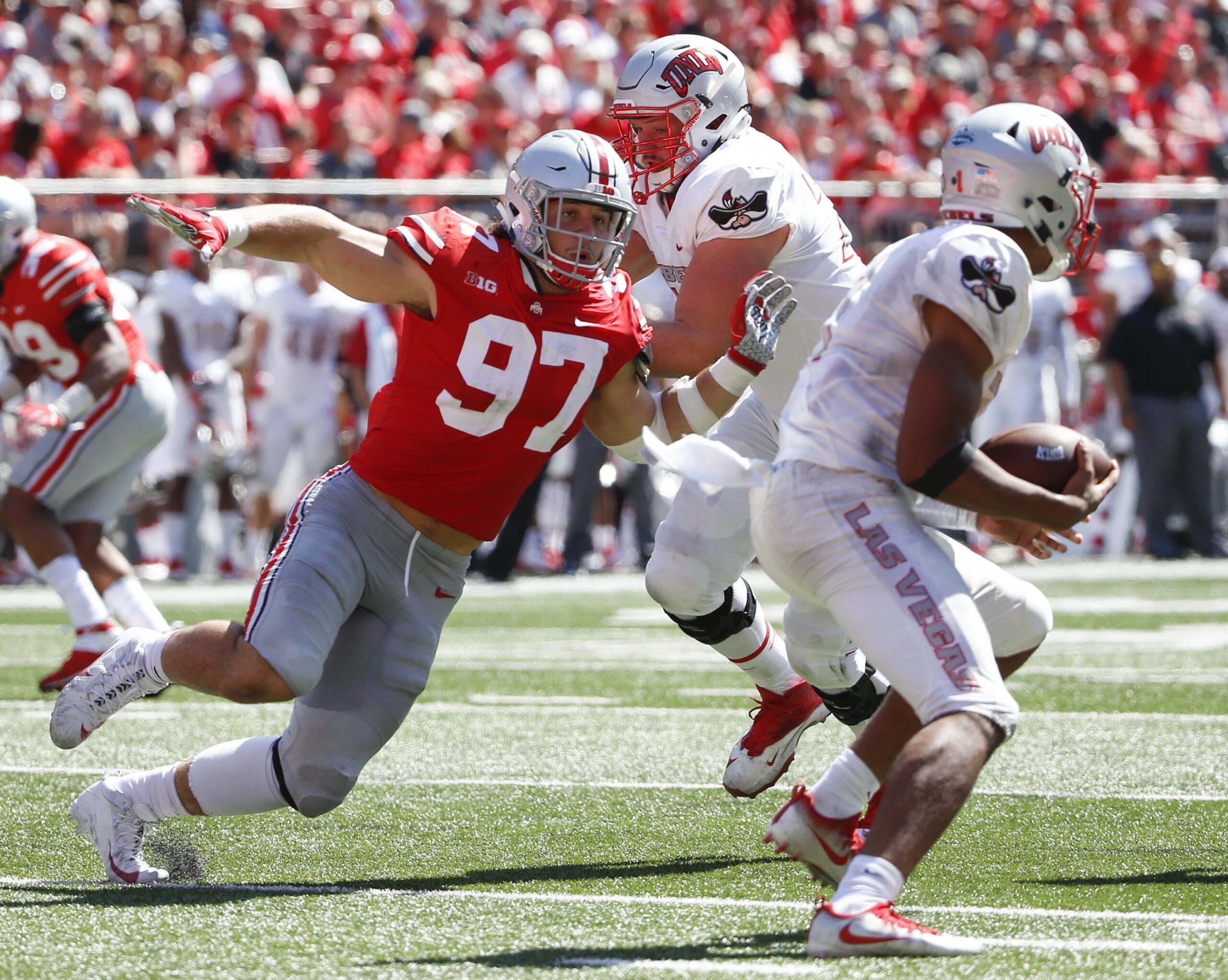 Ohio State Buckeyes defensive lineman Nick Bosa (97) chases down UNLV Rebels quarterback Armani Rogers (1) under pressure from UNLV Rebels offensive lineman Kyle Saxelid, center, during the second quarter of a NCAA college football game between the Ohio State Buckeyes and the UNLV Rebels on Saturday, September 23, 2017 at Ohio Stadium in Columbus, Ohio. [Joshua A. Bickel/Dispatch]

1013108925 Oh Col Osufb