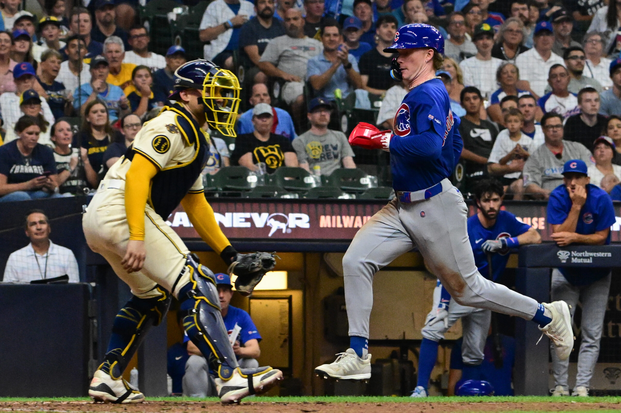 Jul 30, 2025; Milwaukee, Wisconsin, USA; Chicago Cubs center fielder Pete Crow-Armstrong (4) scores on a sacrifice fly in the ninth inning as Milwaukee Brewers catcher William Contreras (24) looks on at American Family Field. Mandatory Credit: Benny Sieu-Imagn Images