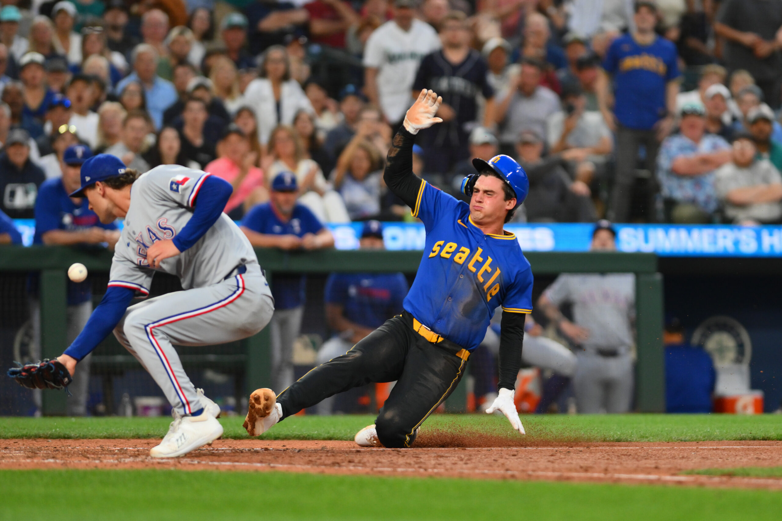 Jul 31, 2025; Seattle, Washington, USA; Seattle Mariners second baseman Cole Young (2) scores a run past Texas Rangers relief pitcher Jacob Latz (67) on a passed ball during the sixth inning at T-Mobile Park. Mandatory Credit: Steven Bisig-Imagn Images
