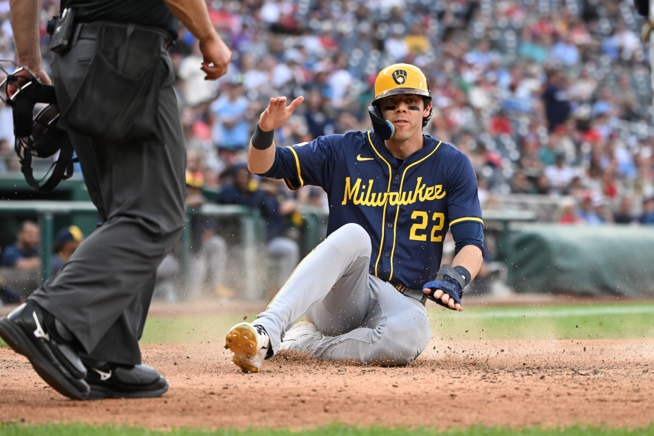 Aug 2, 2025; Washington, District of Columbia, USA; Milwaukee Brewers left fielder Christian Yelich (22) slides into home plate to score a run against the Washington Nationals during the ninth inning at Nationals Park. Mandatory Credit: Rafael Suanes-Imagn Images