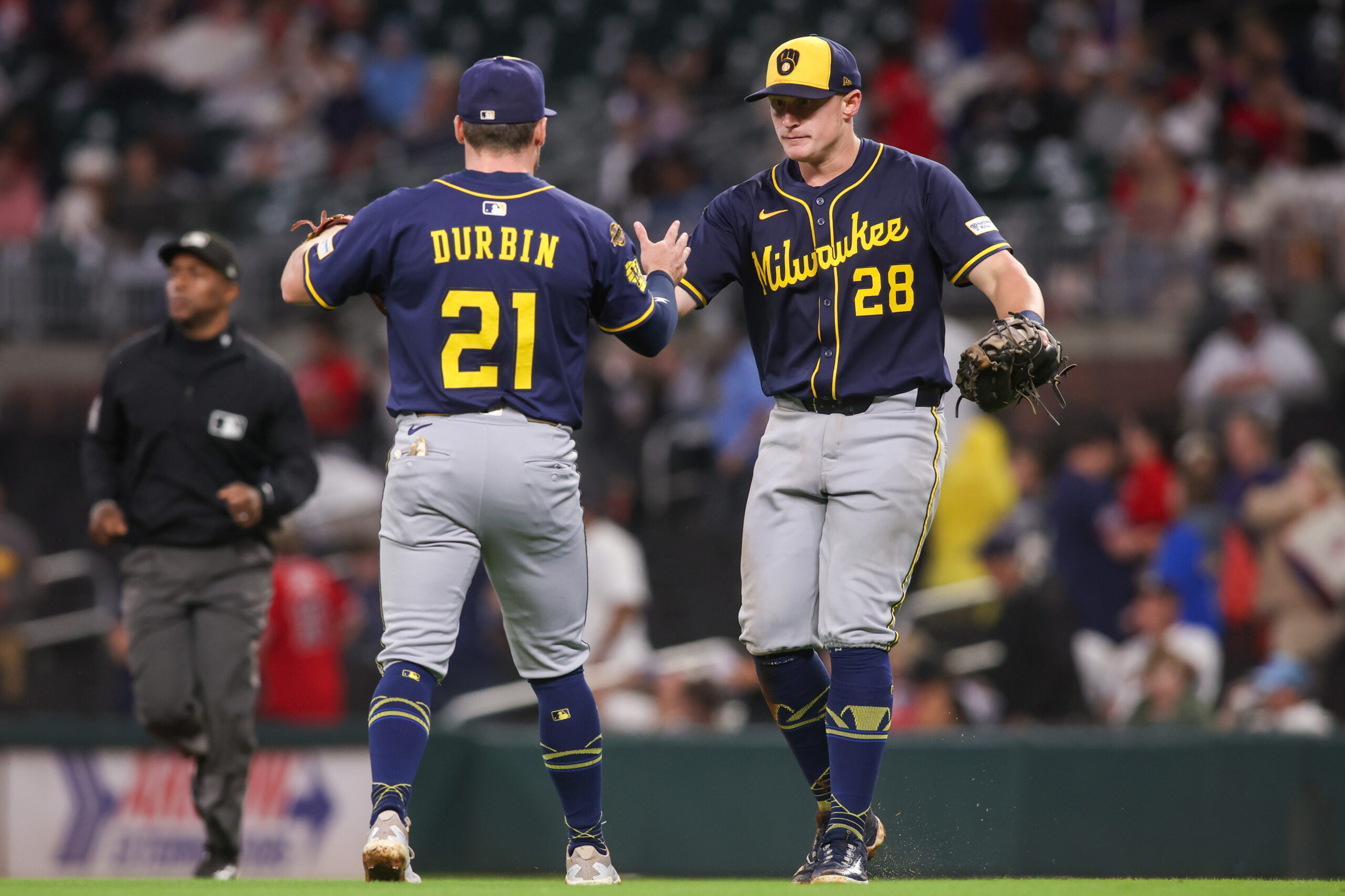 Aug 4, 2025; Atlanta, Georgia, USA; Milwaukee Brewers third baseman Caleb Durbin (21) and first baseman Andrew Vaughn (28) celebrate after a victory over the Atlanta Braves in the ninth inning at Truist Park. Mandatory Credit: Brett Davis-Imagn Images