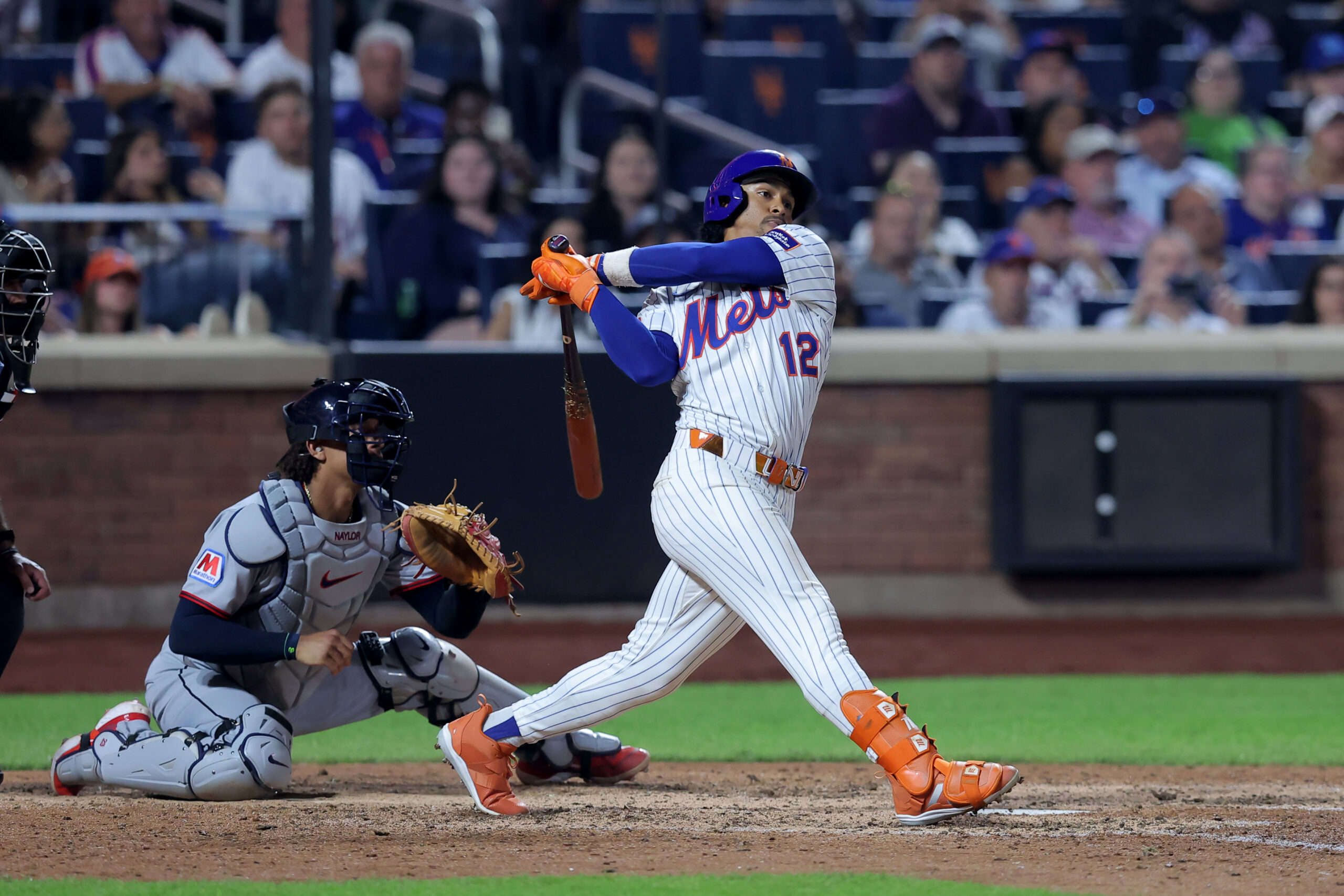 Aug 4, 2025; New York City, New York, USA; New York Mets shortstop Francisco Lindor (12) follows through on a double against the Cleveland Guardians during the ninth inning at Citi Field. Mandatory Credit: Brad Penner-Imagn Images