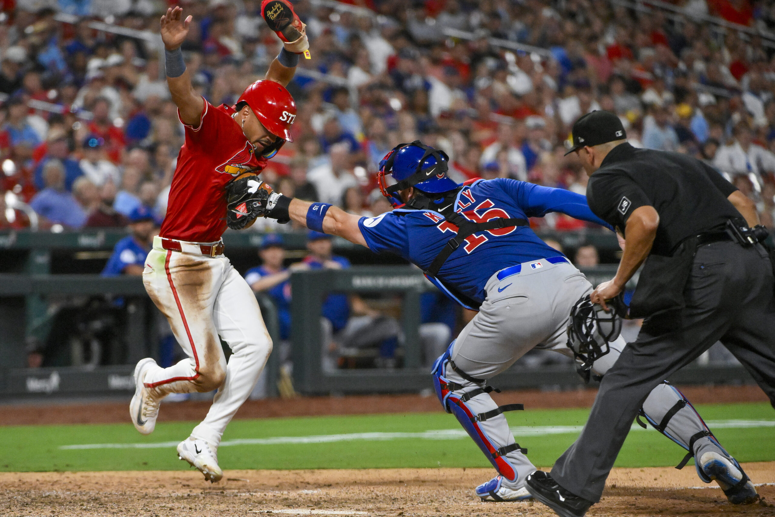 Aug 8, 2025; St. Louis, Missouri, USA; St. Louis Cardinals shortstop Masyn Winn (0) is tagged out by Chicago Cubs catcher Carson Kelly (15) during the eighth inning at Busch Stadium. Mandatory Credit: Jeff Curry-Imagn Images