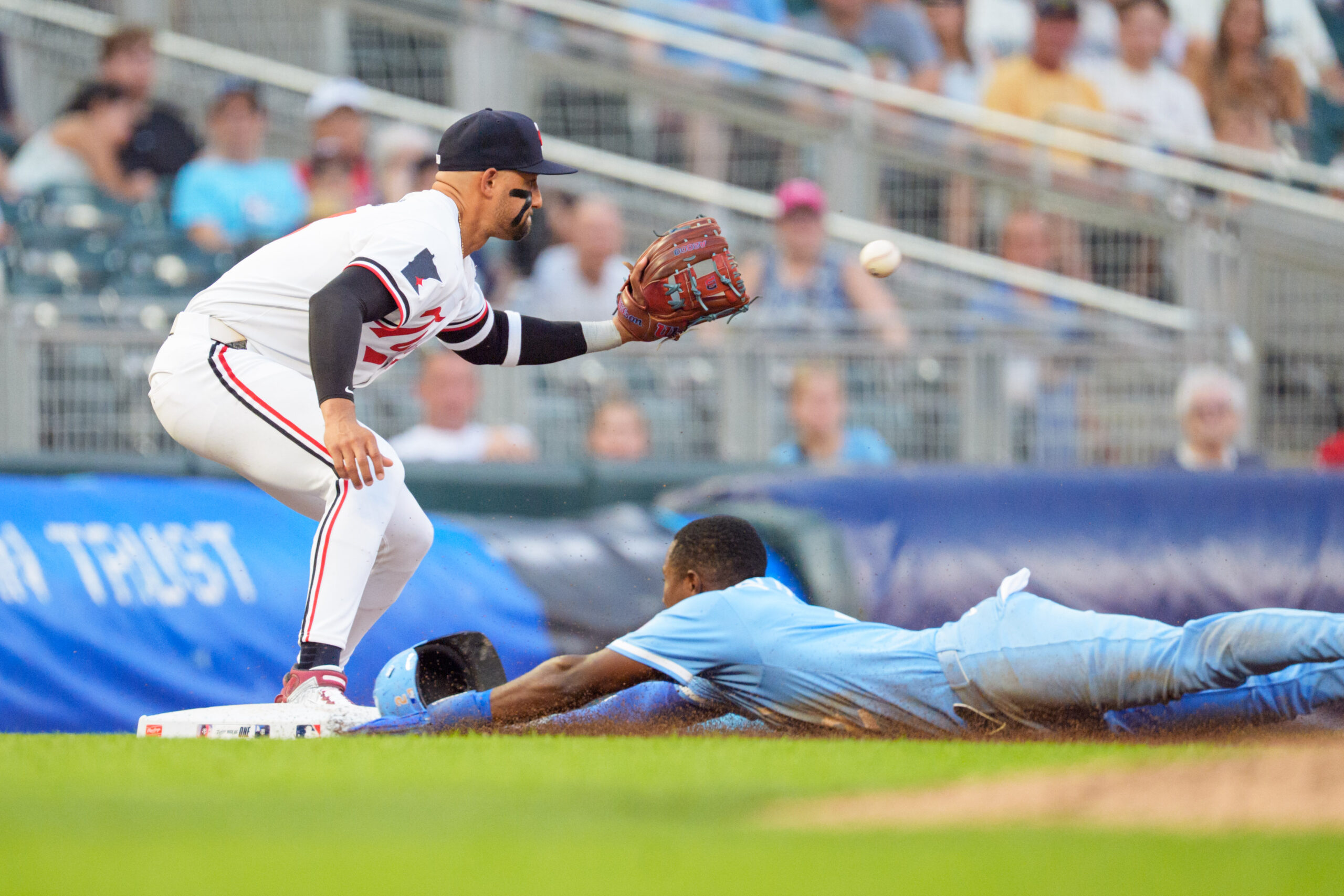 Aug 9, 2025; Minneapolis, Minnesota, USA; Kansas City Royals second base Tyler Tolbert (2) slides into third base as the ball reaches Minnesota Twins catcher Ryan Jeffers (27) in the seventh inning at Target Field. Mandatory Credit: Matt Blewett-Imagn Images