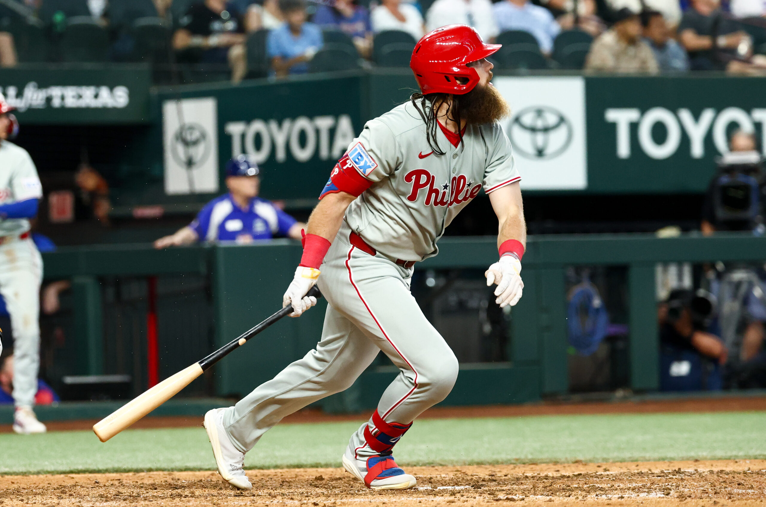 Aug 10, 2025; Arlington, Texas, USA; Philadelphia Phillies center fielder Brandon Marsh (16) hits an rbi sacrifice fly during the ninth inning against the Texas Rangers at Globe Life Field. Mandatory Credit: Kevin Jairaj-Imagn Images