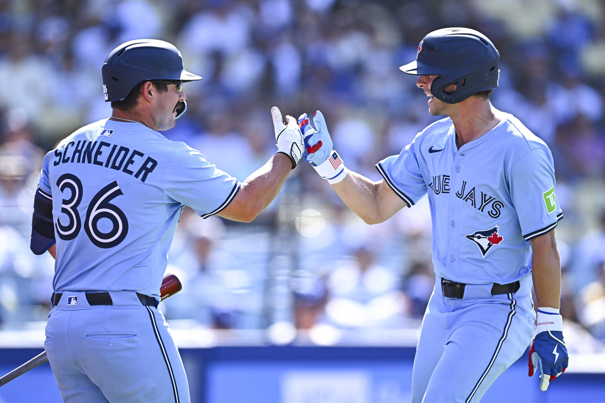 Aug 10, 2025; Los Angeles, California, USA; Toronto Blue Jays second baseman Ernie Clement (22) celebrates with outfielder Davis Schneider (36) after hitting a solo home run against the Los Angeles Dodgers during the ninth inning at Dodger Stadium. Mandatory Credit: Jonathan Hui-Imagn Images